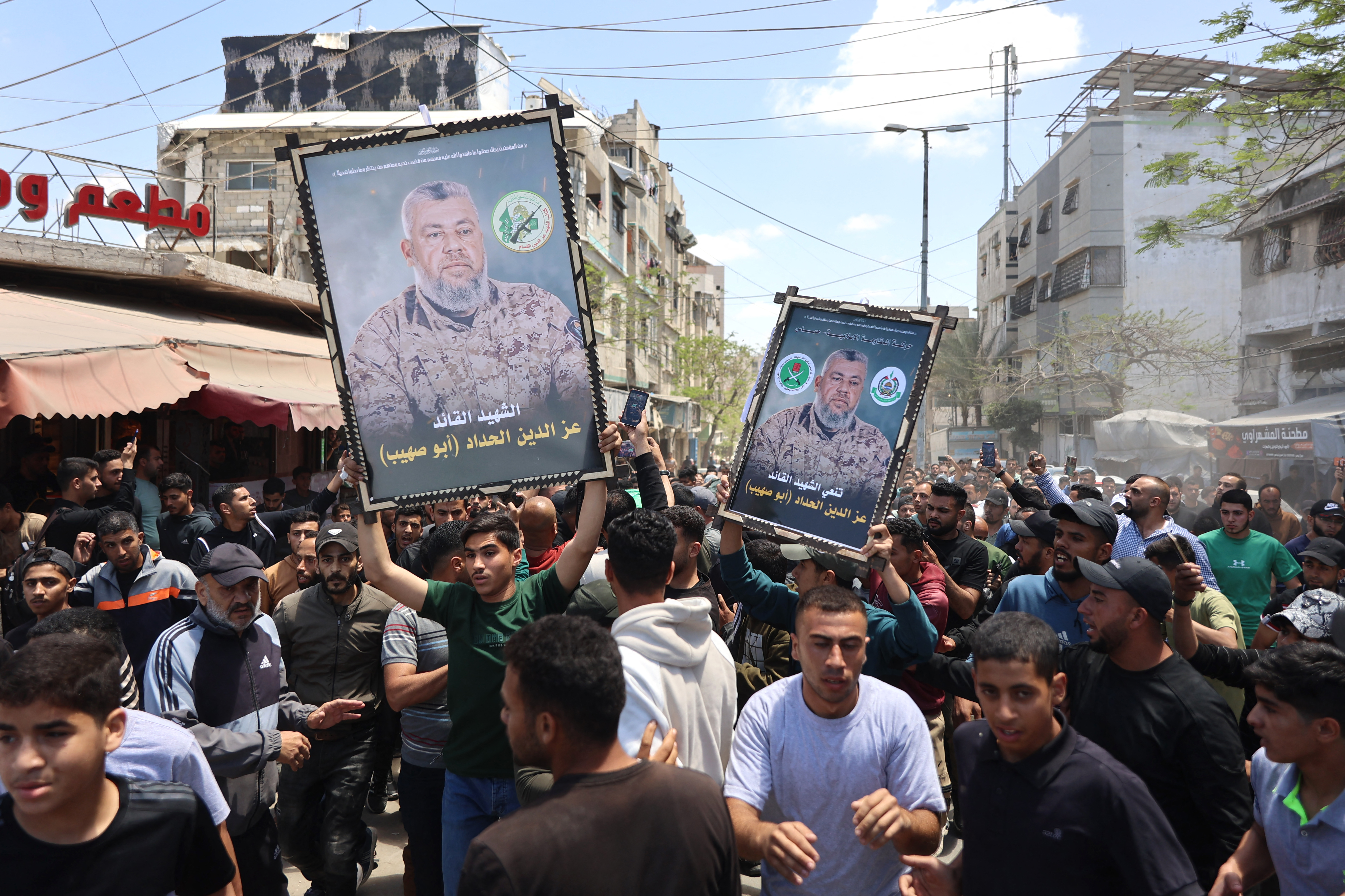 EDITORS NOTE: Graphic content / Mourners carry portraits of Ezzedine Al-Haddad, the slain chief of the Qassam Brigades -- the armed wing of Palestinian movement Hamas, who was killed in an overnight Israeli strike along with his daughter and wife, during their funeral in Gaza City on May 16, 2026.