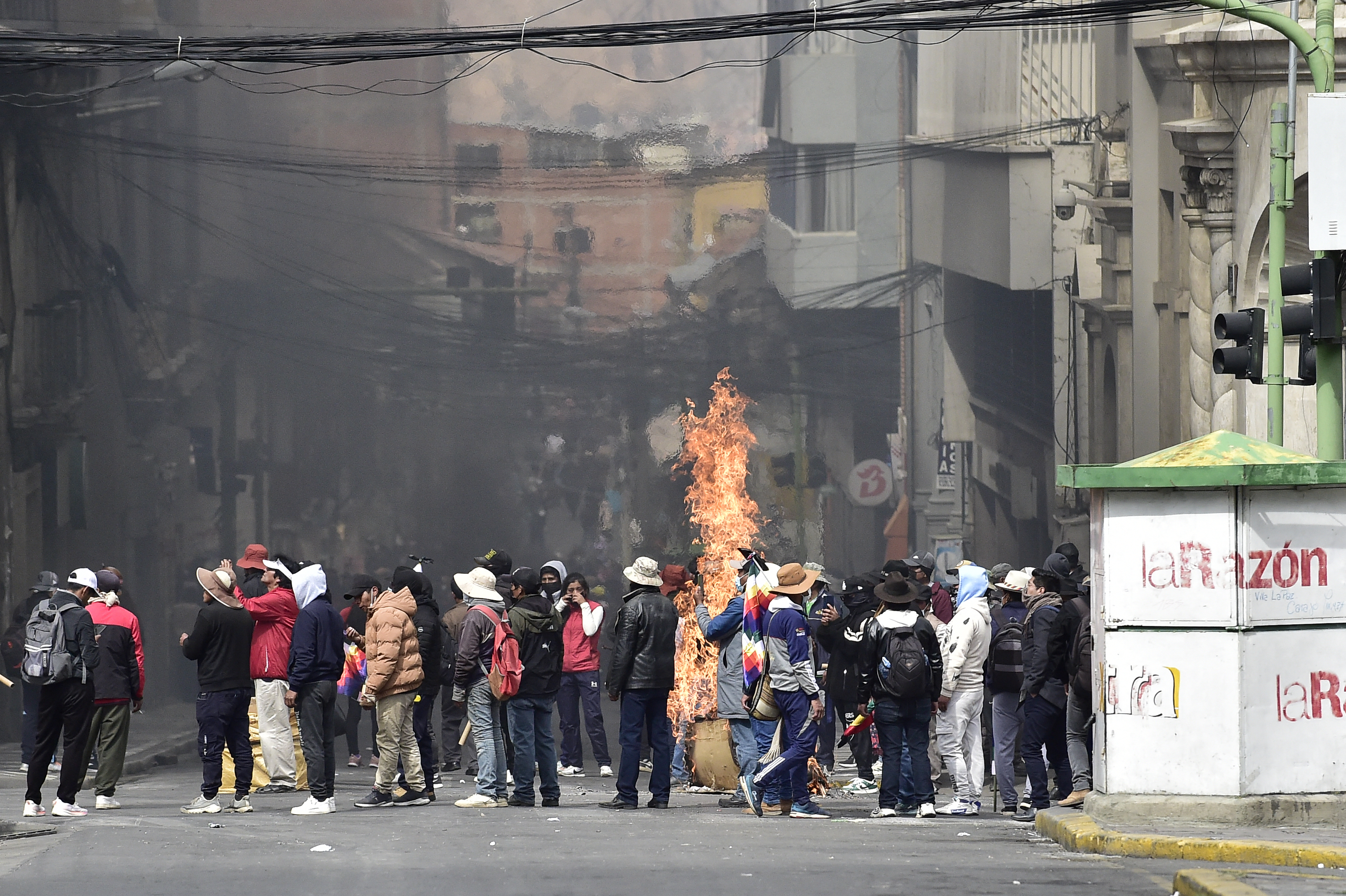 Flames rise from a cardboard box as miners clash with riot police during a protest demanding the resignation of Bolivian President Rodrigo Paz, in La Paz, on May 18, 2026.