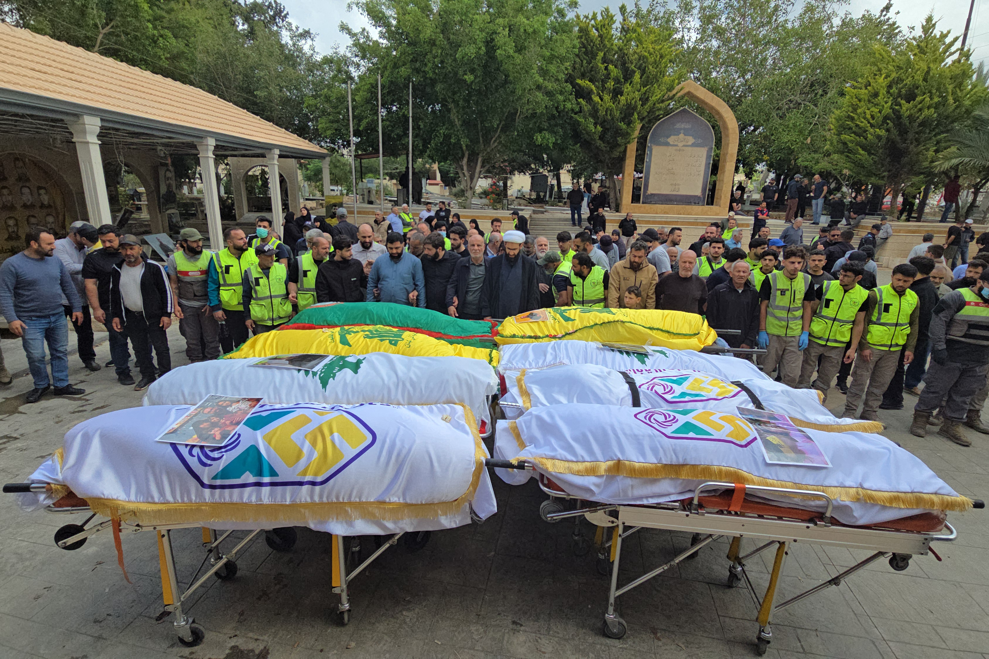 Mourners stand next to bodies of victims killed in the Israeli strike on the southern village of Deïr Qanoun en Nahr after arriving in their hometown for a burial in the Tyre area of south Lebanon, as security conditions prevented families from holding the farewell ceremony in the village, on May 21, 2026.