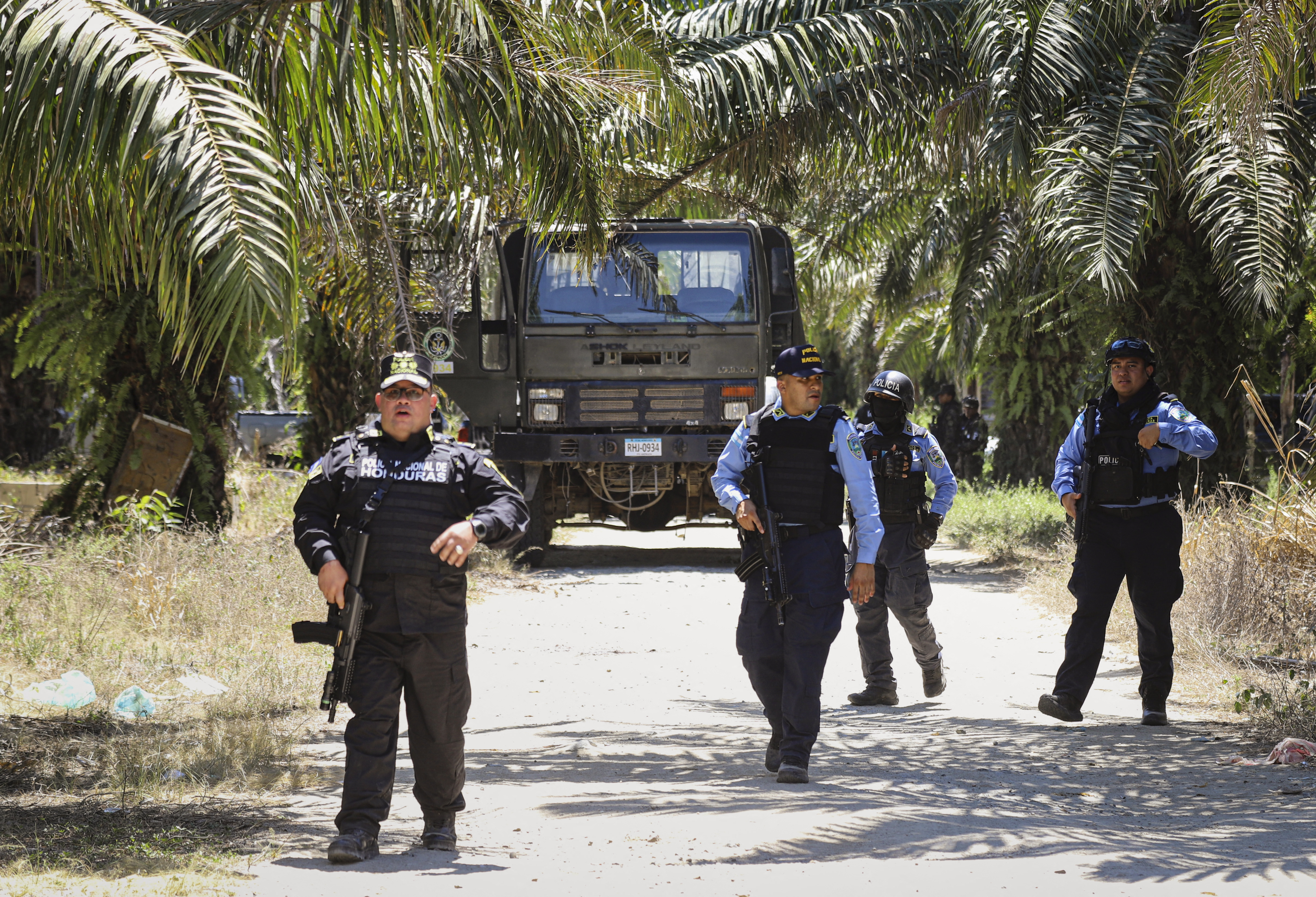 Police officers patrol near the site of a massacre in Trujillo, Honduras