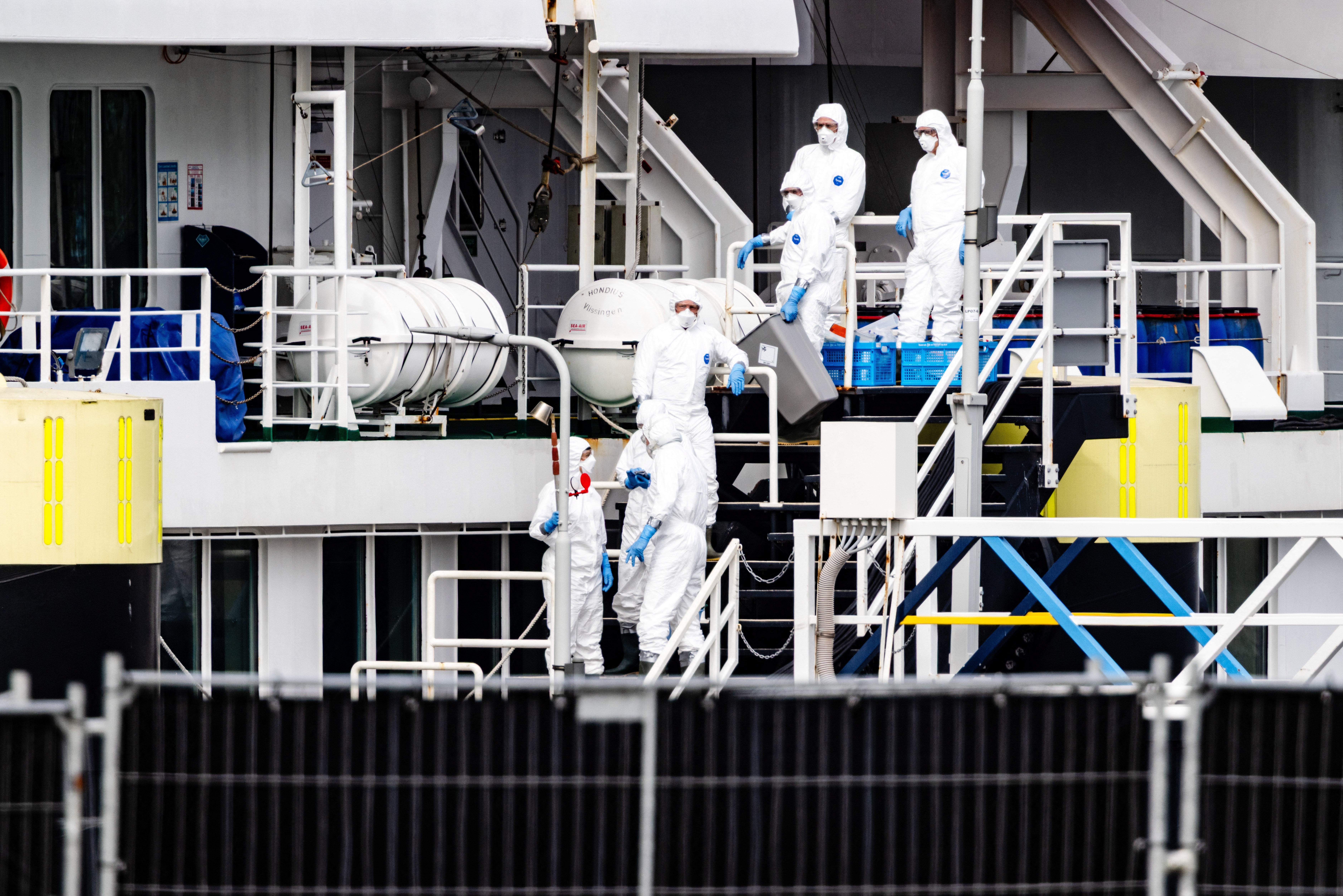 Personnel in personal protection equipment suits gather onboard the Dutch Hantavirus-hit cruise ship MV Hondius in the port of Rotterdam on May 19, 2026.