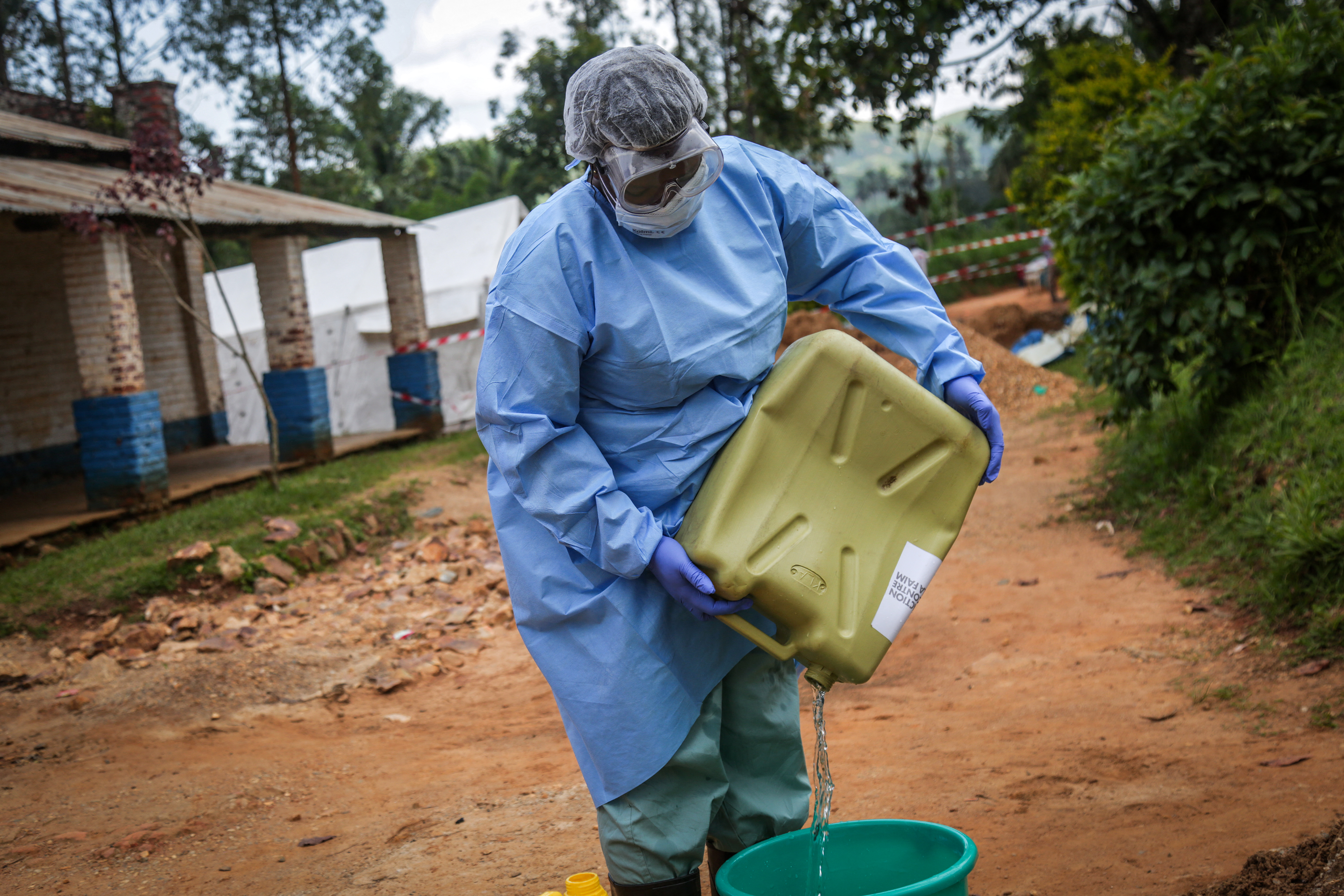 A health worker wearing protective equipment prepares disinfectant materials as she gets ready to disinfect the isolation area for Ebola patients at the General Referral Hospital of Mongbwalu in Mongbwalu [AFP]