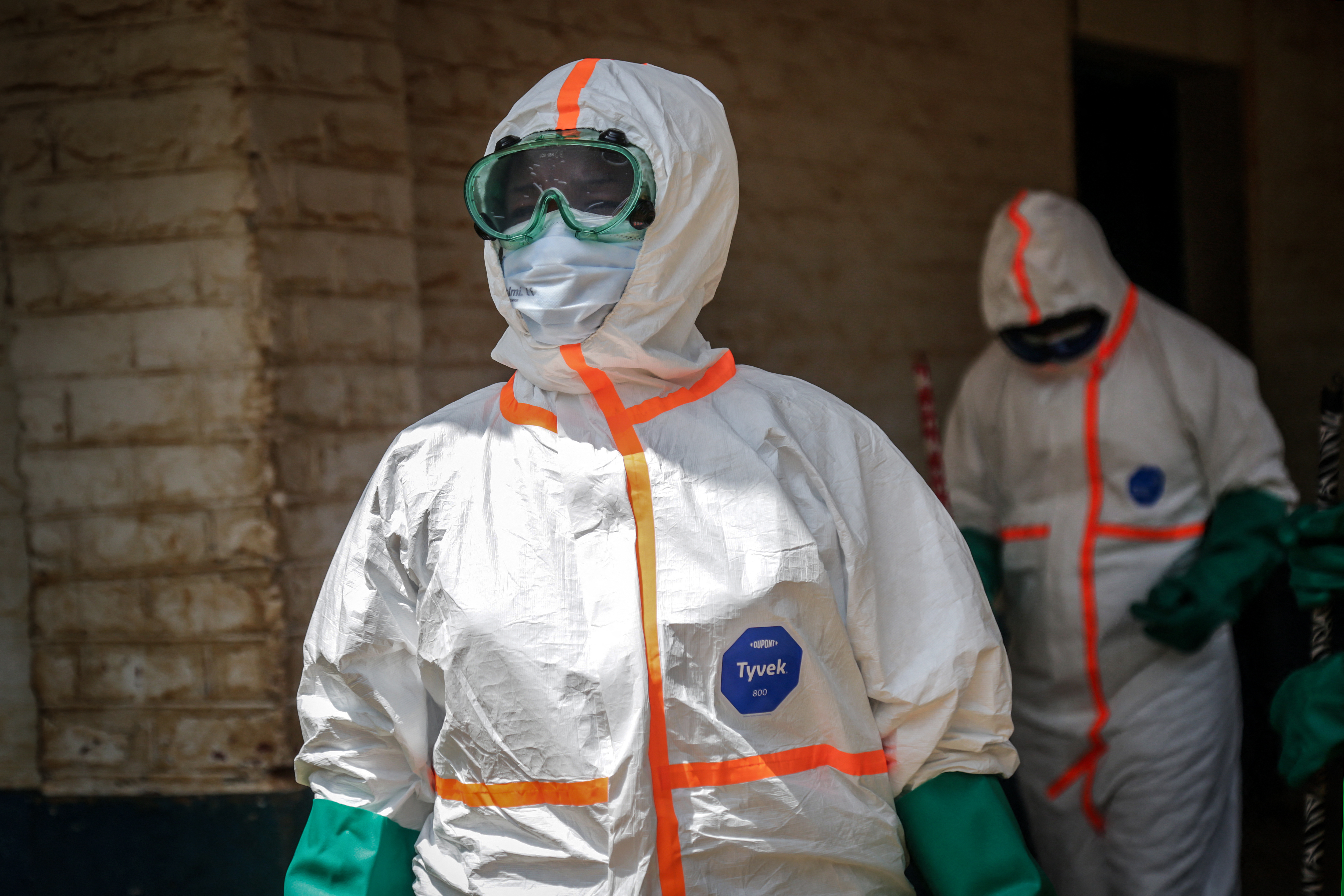 Health workers wearing protective equipment gather to disinfect the isolation area for Ebola patients at the General Referral Hospital of Mongbwalu [AFP]