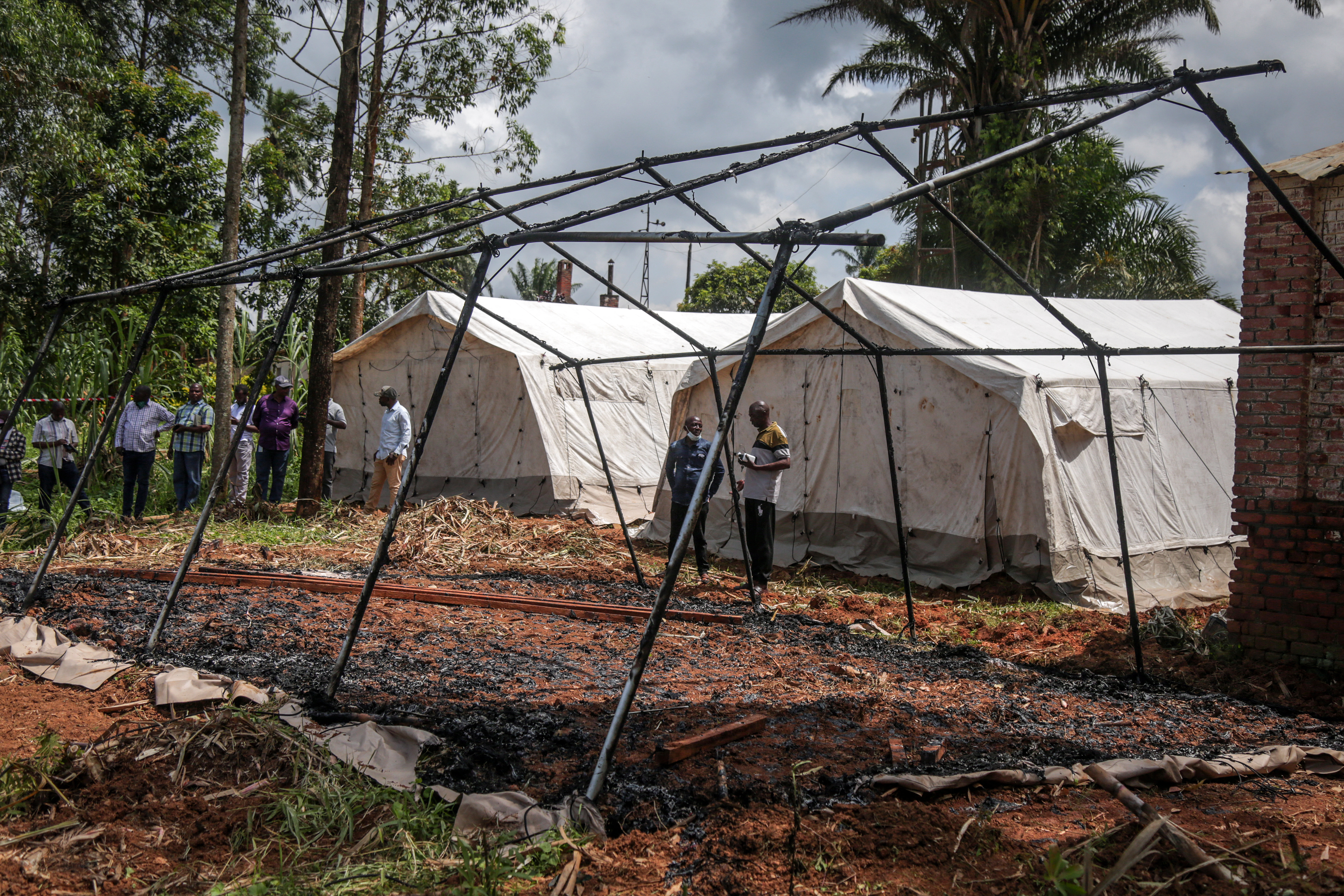 Residents gather to inspect the remains of Residents gather to inspect the remains of a burnt medical tent at the General Referral Hospital of Mongbwalu [AFP]