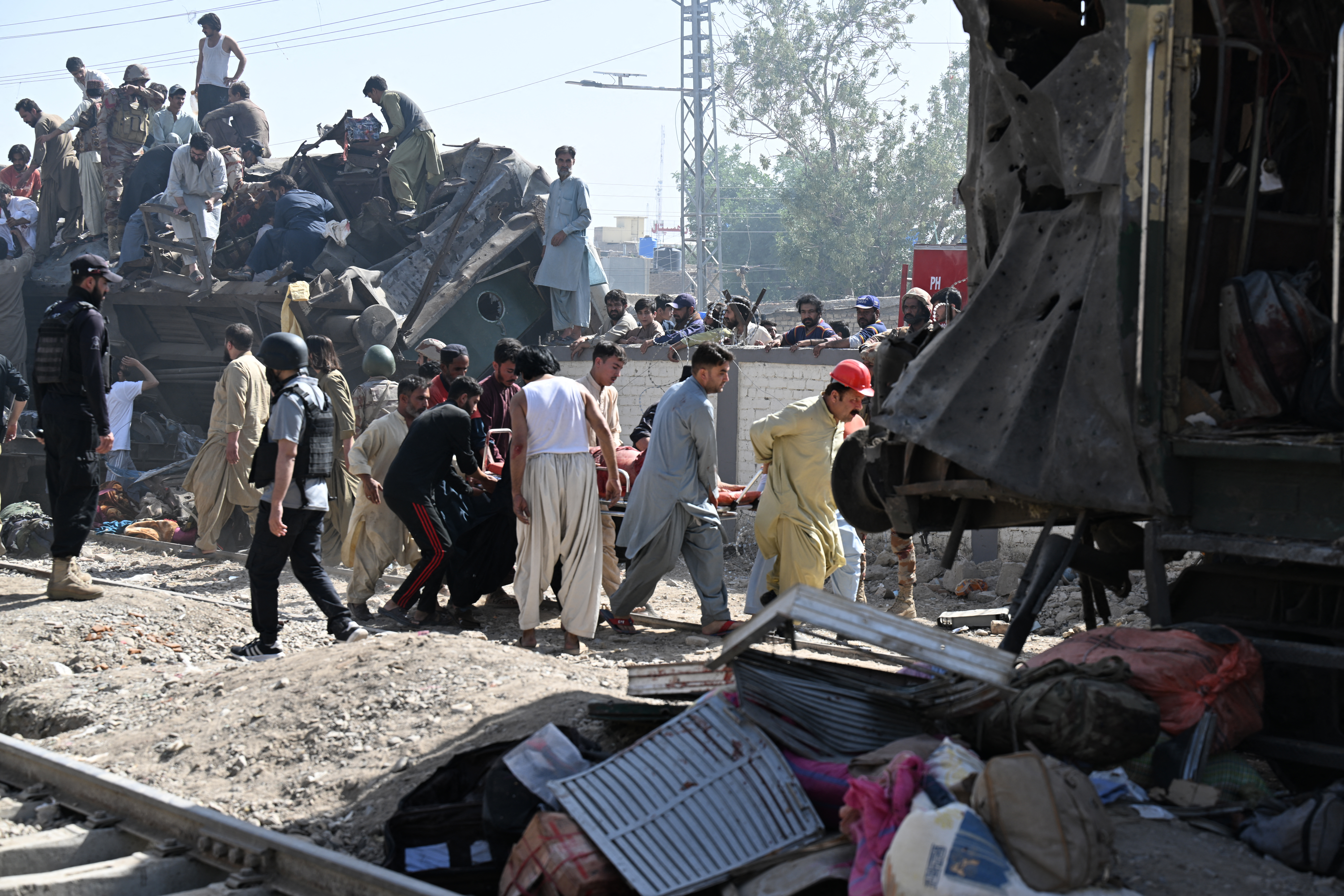Security personnel and residents rescue injured blast victims from derailed carriages after an explosion targeted a train in Quetta, in Pakistan's Balochistan province