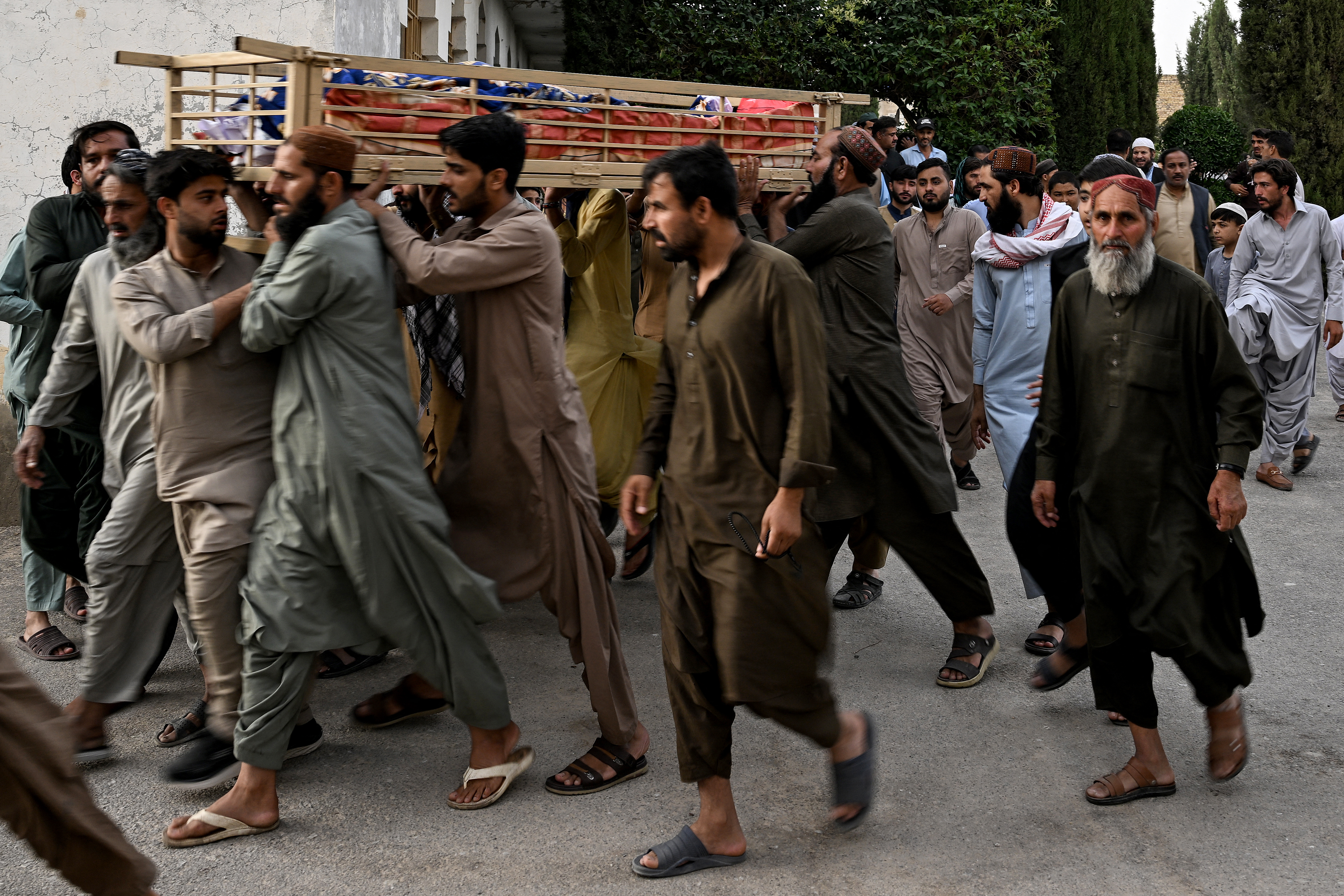 Mourners carry the coffin of a train blast victim during a funeral ceremony in Quetta on May 24, 2026.