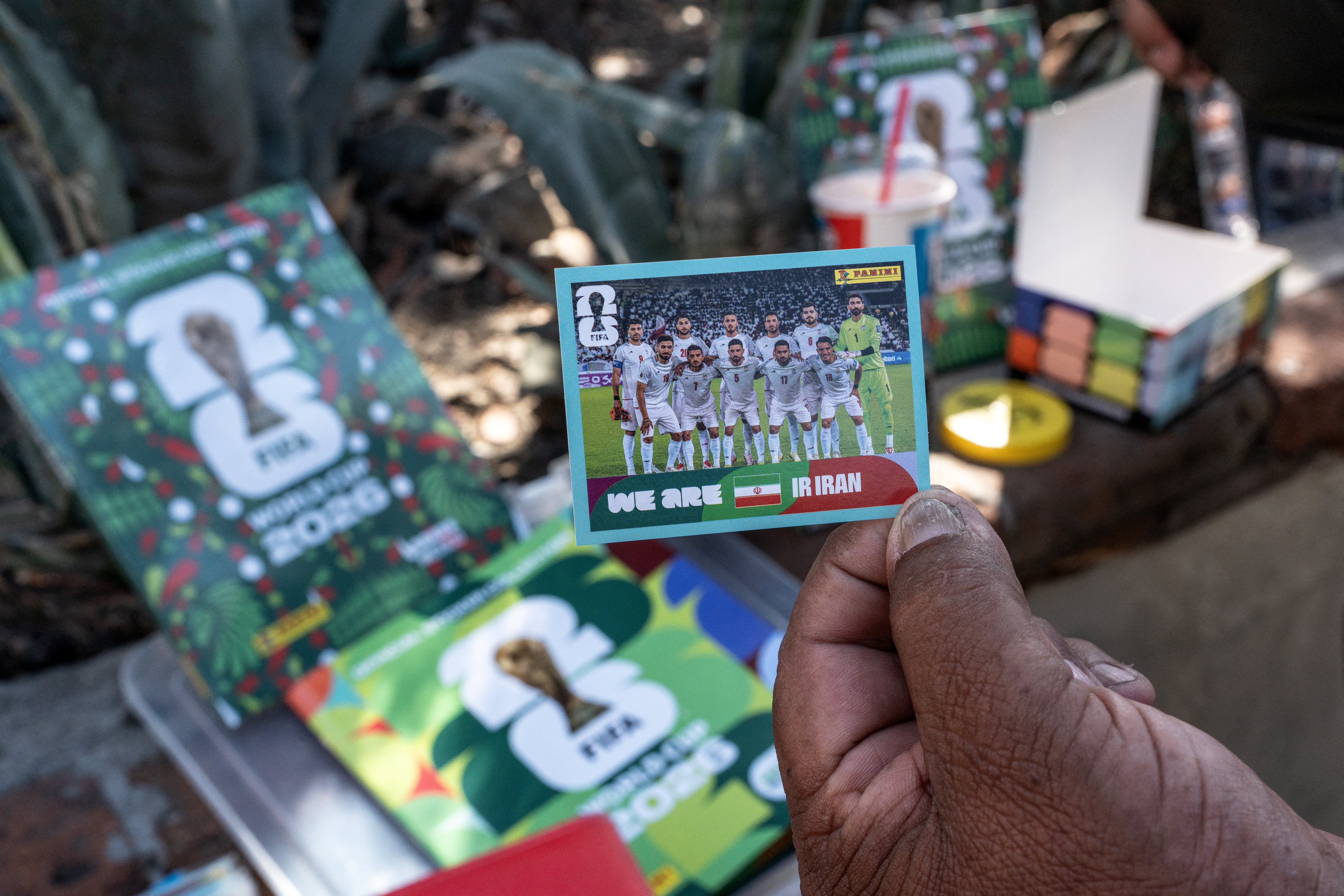 A vendor shows a Panini sticker featuring the Iran national football team for the World Cup in Tijuana, Baja California state, Mexico on May 23, 2026.