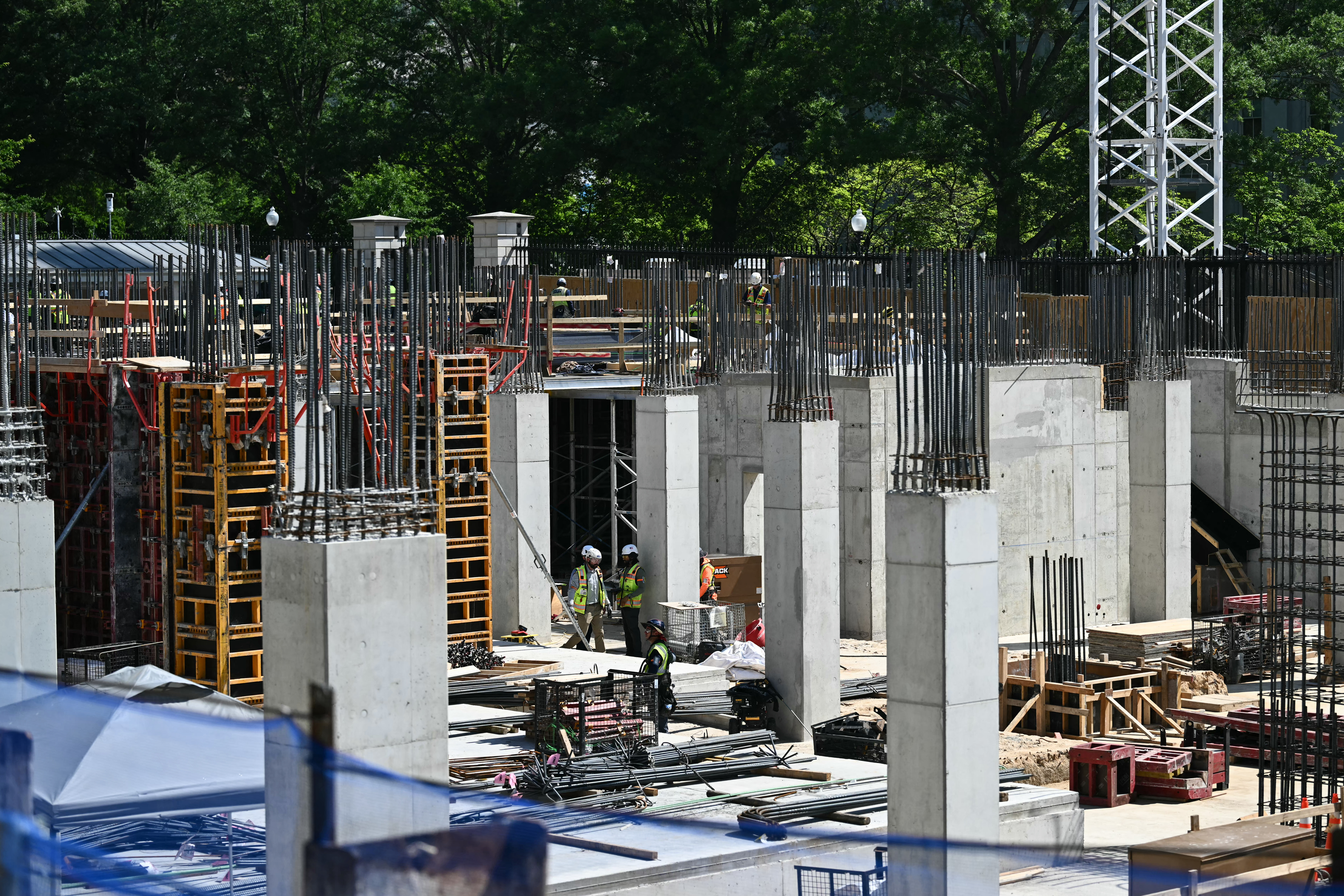 Workers are seen as US President Donald Trump speaks to the press near the construction site of his proposed ballroom at the White House in Washington, DC, on May 19, 2026. (Photo by Kent NISHIMURA / AFP)
