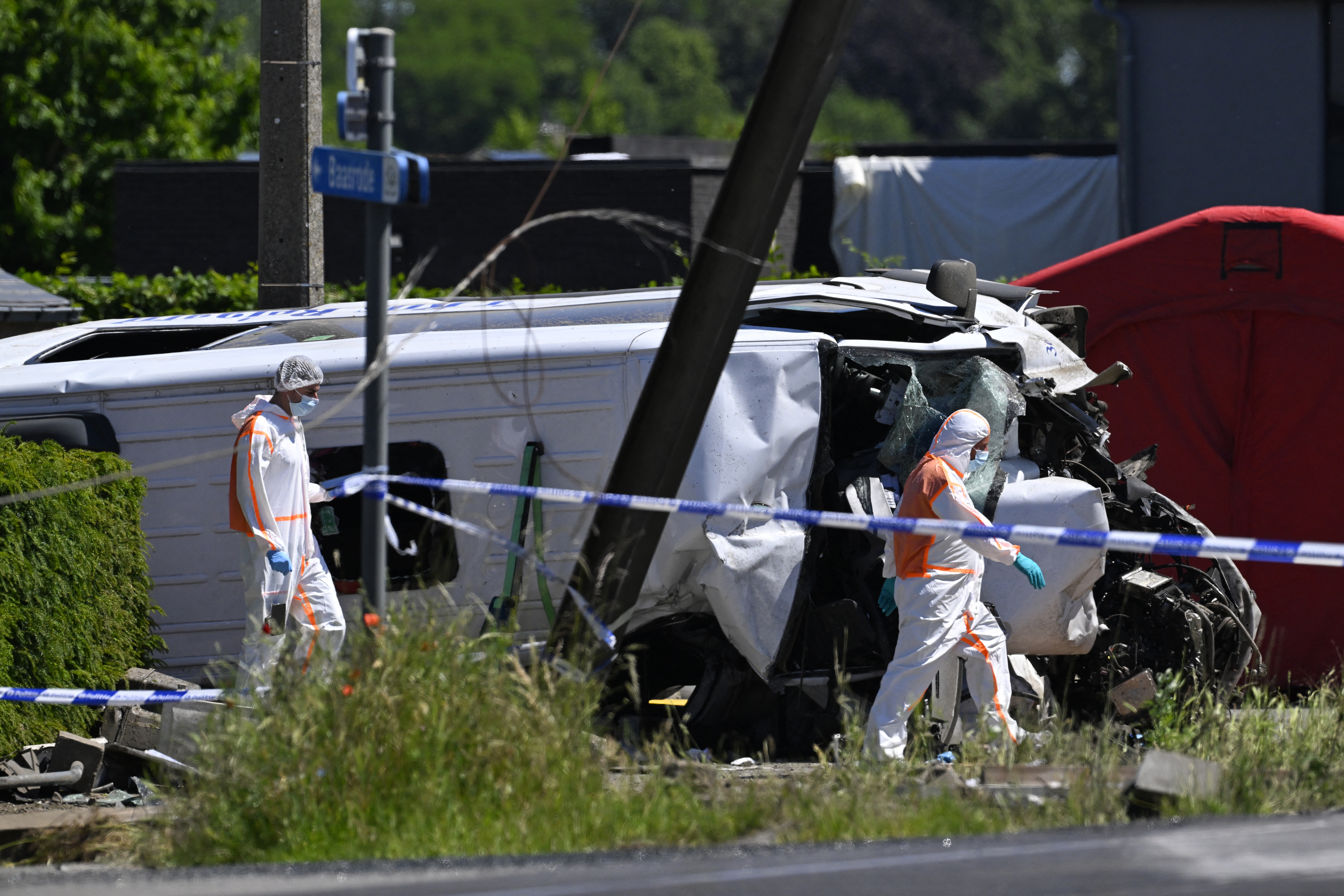 Forensic Police officers inspect next to the damaged bus at the site of an accident after a train crashed into a school bus, at the railway crossing Vierhuizen in Buggenhout, some 20kms north of Brussels on May 26, 2026.