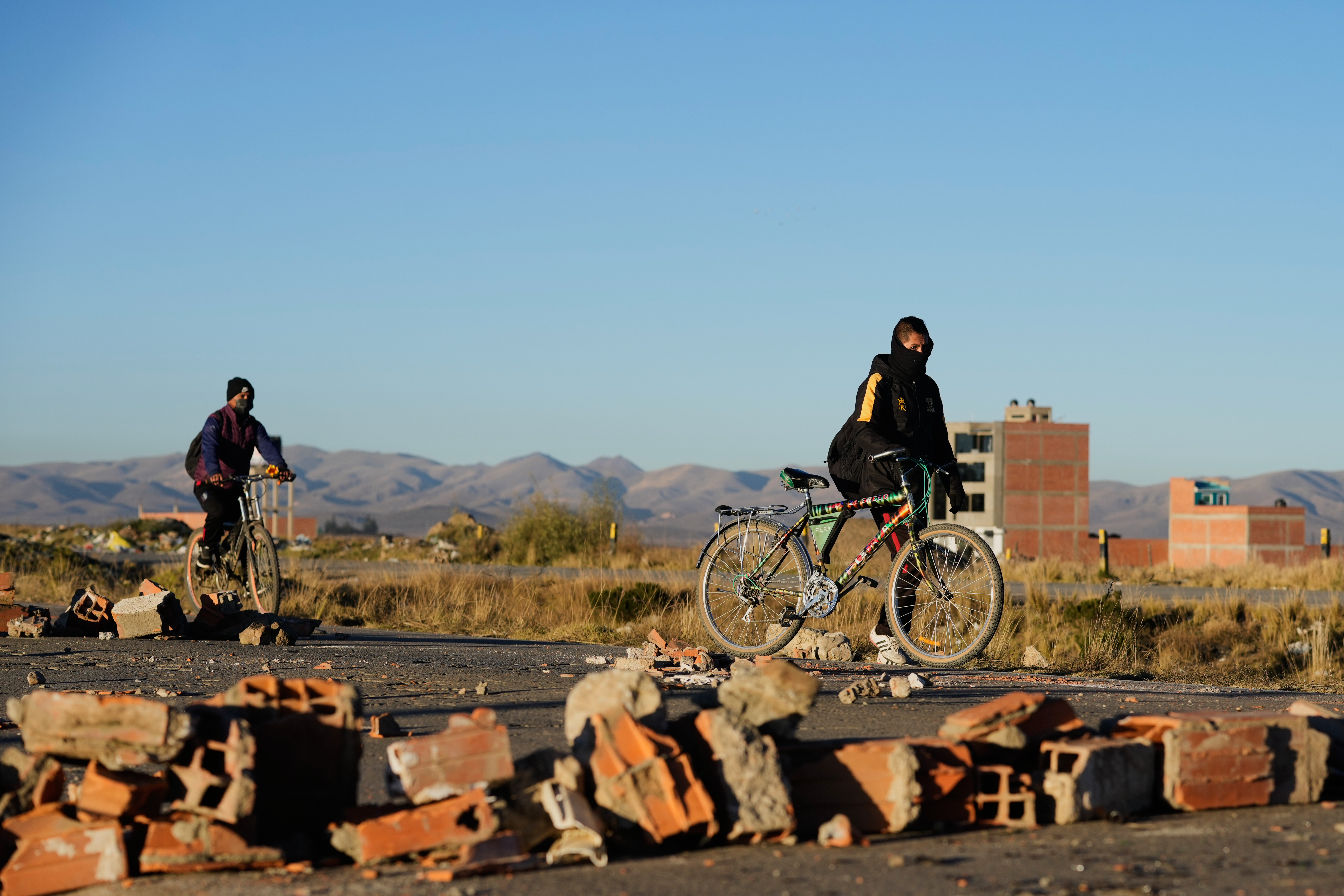People ride around barricades set up by protesters on the highway connecting La Paz with Oruro near El Alto, Bolivia, Saturday, May 16, 2026. (AP Photo/Juan Karita)
