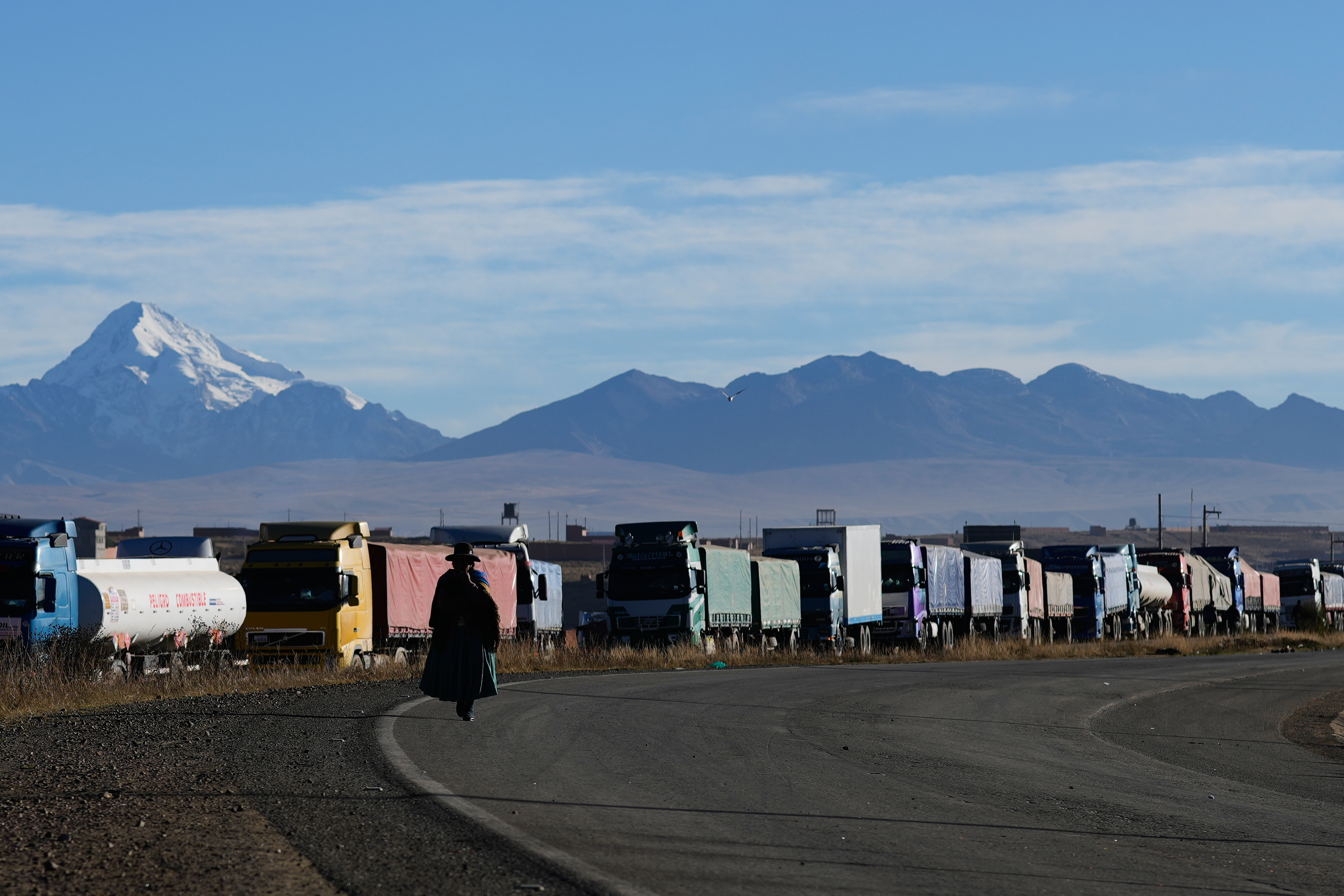 Trucks line up on the highway connecting La Paz with Oruro after anti-government protesters blocked the road near El Alto, Bolivia, Saturday, May 16, 2026. (AP Photo/Juan Karita)