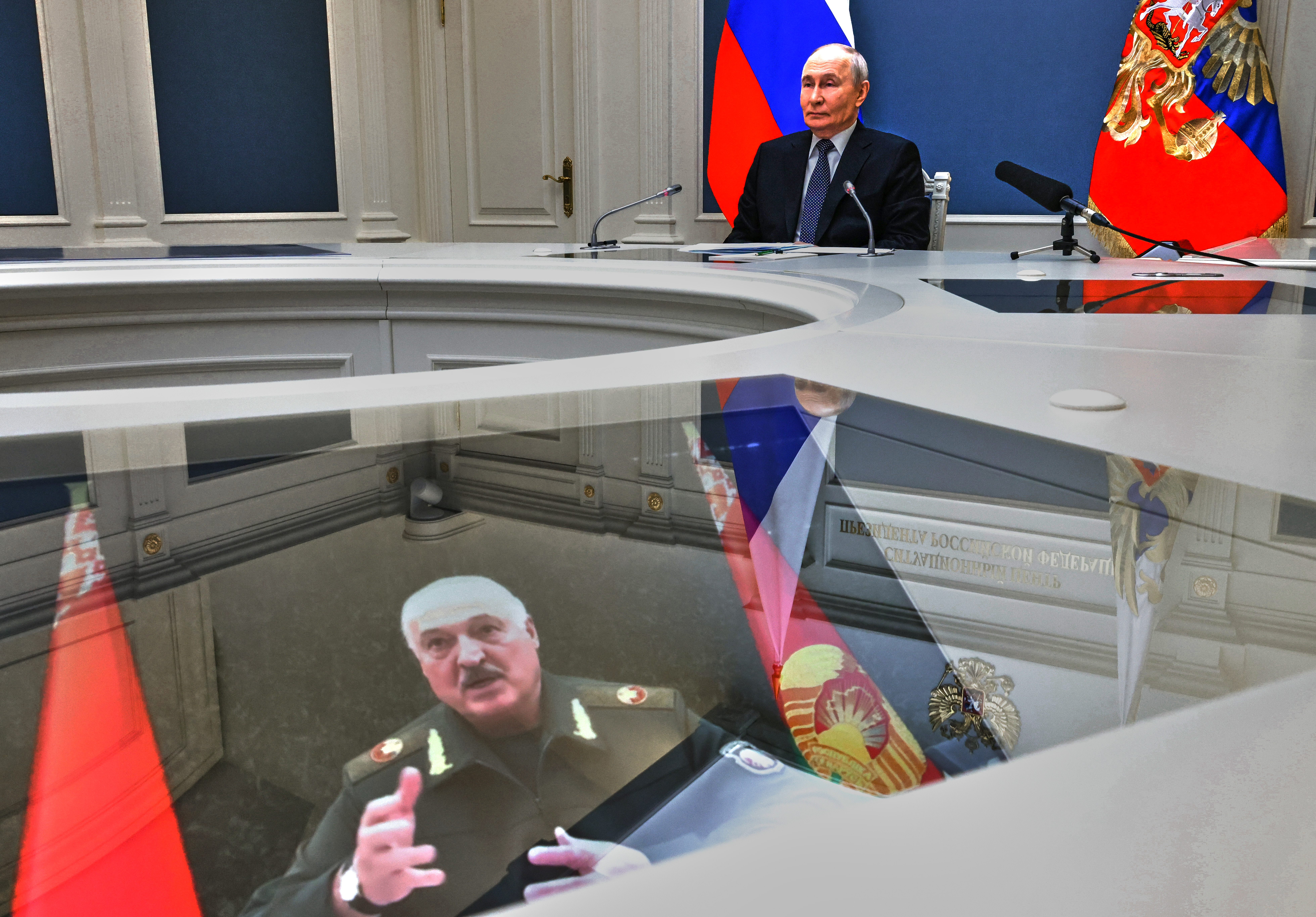 Russian President Vladimir Putin and his Belarusian counterpart Alexander Lukashenko, seen at the screen, take part in a video call as part of joint nuclear drills at the Presidential Situation Centre at the Kremlin in Moscow, Thursday, May 21, 2026. (Mikhail Metzel/Sputnik, Kremlin Pool Photo via AP)