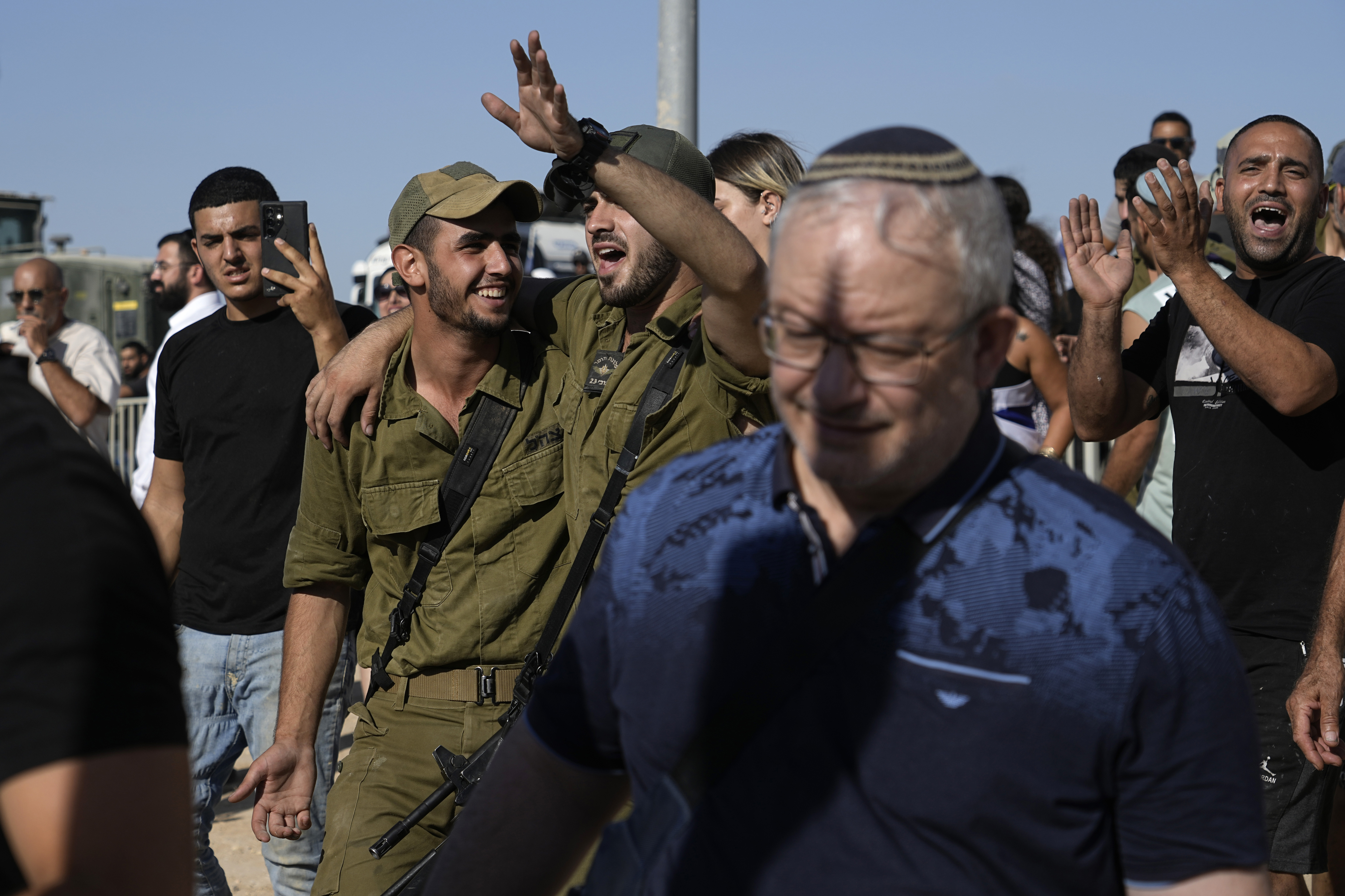 Israeli soldiers going a protest at the gate to Sde Teiman military base, in support of soldiers being questioned for detainee abuse, Monday, July 29, 2024. The Israeli military said Monday it was holding nine soldiers for questioning following allegations of "substantial abuse" of a detainee at a shadowy facility where Israel has held Palestinian prisoners throughout the war in Gaza. (AP Photo/Tsafrir Abayov)
