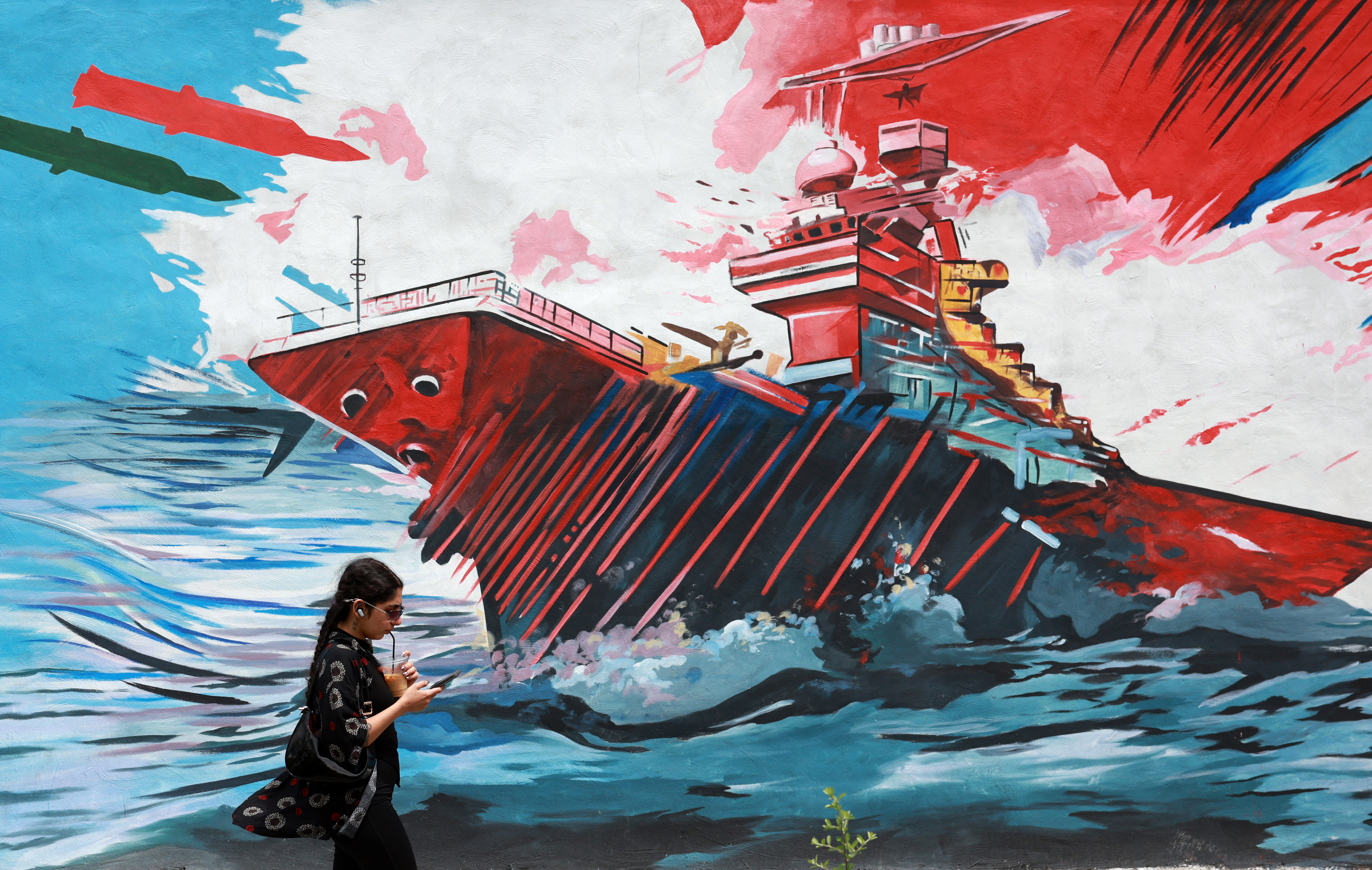 epa12931847 An Iranian walks next to an anti-US mural in a street in Tehran, Iran, 04 May 2026. Iranian Foreign Ministry Spokesman Esmaeil Baghaei criticized the US president's plans on the passage of vessels through the Strait of Hormuz, a day after Donald Trump said that Washington would begin escorting ships through the waterway. EPA/ABEDIN TAHERKENAREH