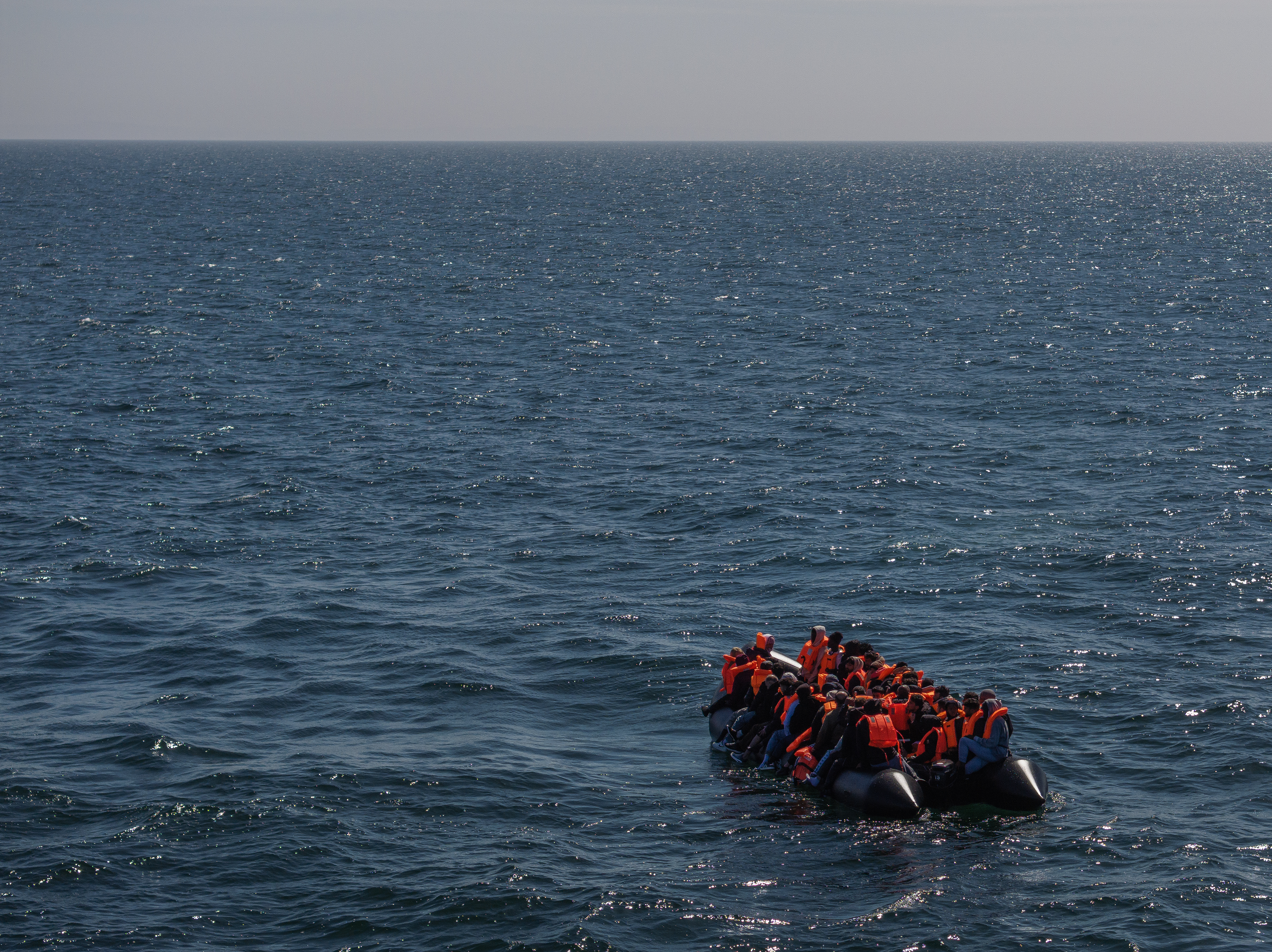 AT SEA, ENGLAND - APRIL 27: An inflatable 'small boat' carrying migrants crosses the channel after leaving northern France on April 27, 2026 in Dover, England. Last week the UK and France signed a £662 million, three-year deal to curb small boat crossings, featuring a first-of-its-kind £160 million "results-based" payment conditional on a reduction in arrivals. The agreement funds a 42% increase in French coastal personnel, a new removal centre in Dunkirk, and advanced surveillance technology. While designed to disrupt smuggling gangs and secure beaches with riot-trained officers, early reports show smugglers have already begun shifting launch sites further south to bypass the intensified patrols. (Photo by Dan Kitwood/Getty Images)