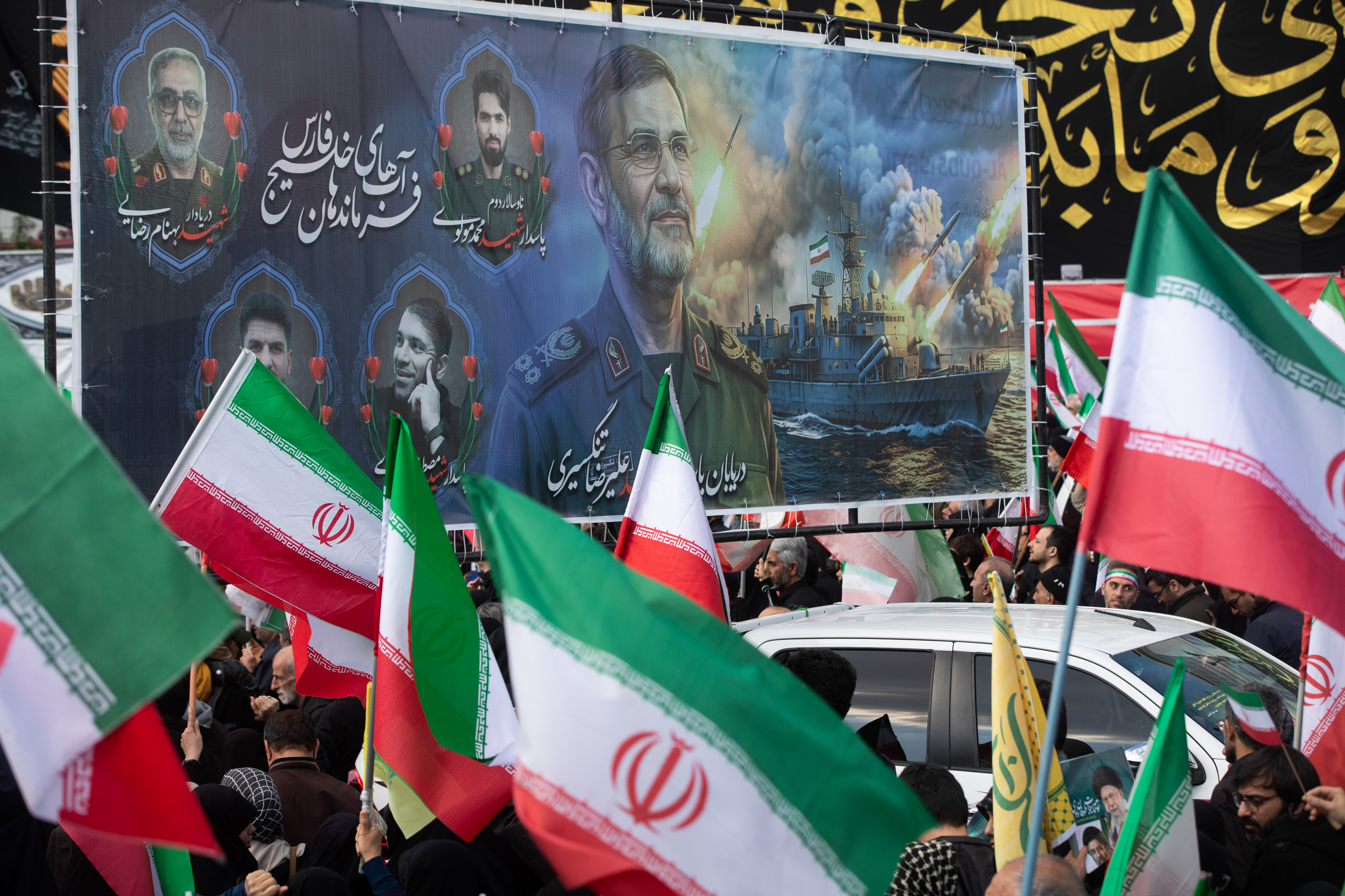TEHRAN, IRAN - APRIL 1: Members of the crown wave Iranian flags during a funeral procession held for IRGC Navy Chief Alireza Tangsiri, alongside other senior naval commanders and their families who were killed in US-Israeli strikes in late March, on April 1, 2026 in Tehran, Iran. The United States and Israel continued their joint attack on Iran that began on February 28. Iran retaliated by firing waves of missiles and drones at Israel, and targeting U.S. allies in the region. (Photo by Majid Saeedi/Getty Images)