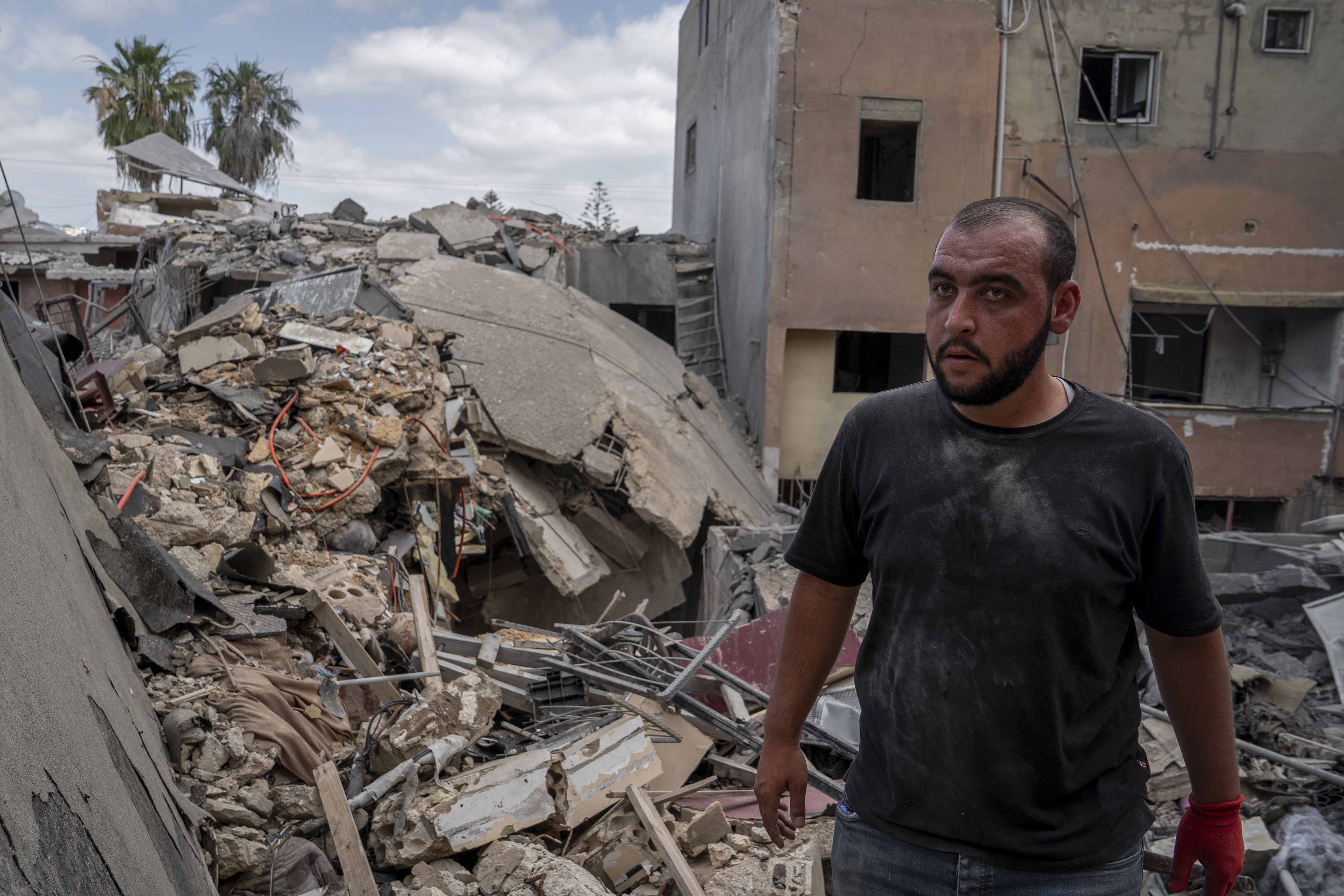 A neighbor walks trough the rubble caused by an Israeli air raid