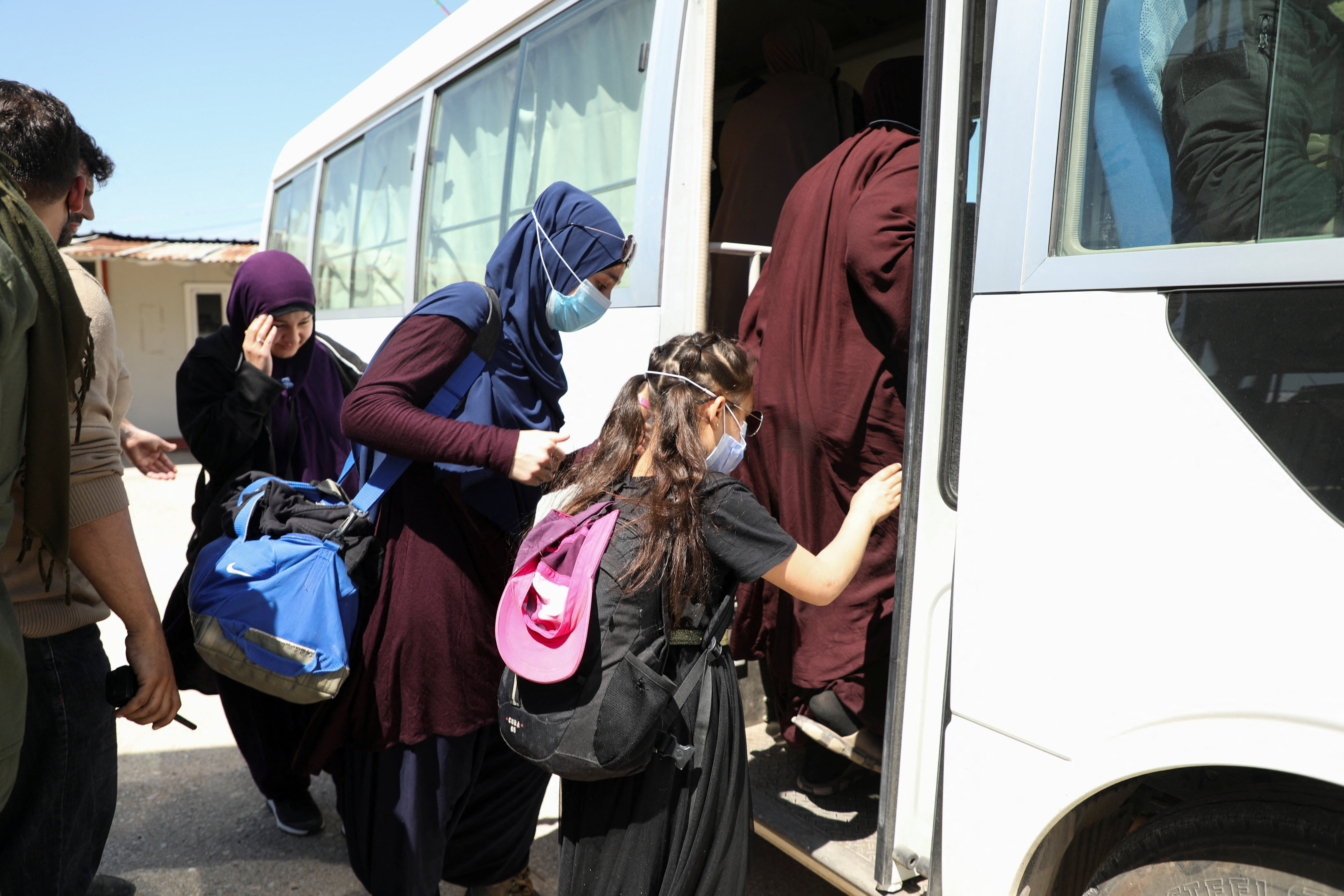 Members of Australian families believed to be linked to the Islamic State group leave Roj camp near Derik, Syria