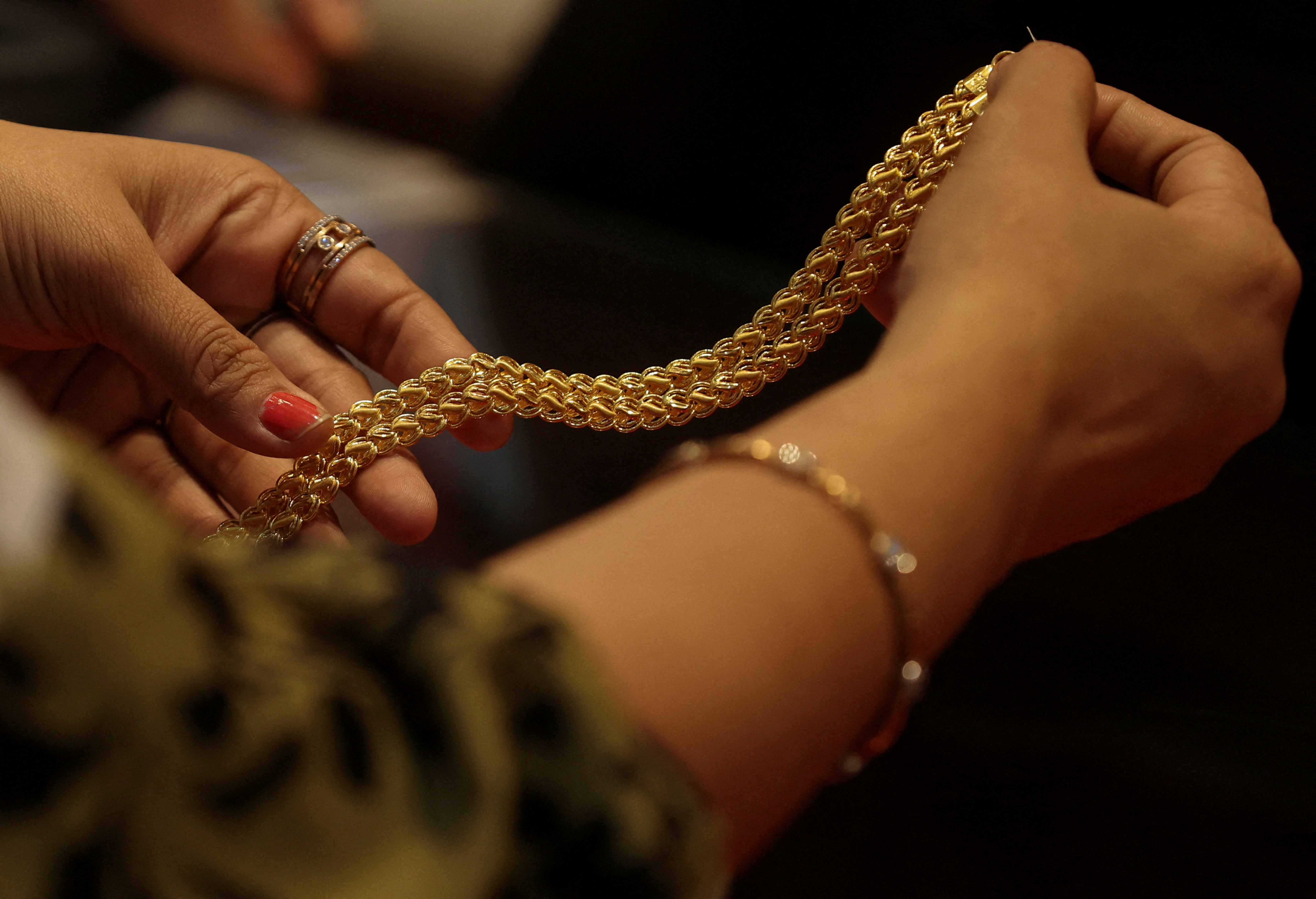 FILE PHOTO: A customer holds a gold chain at a jewellery store in Mumbai, India, January 30, 2026. REUTERS/Francis Mascarenhas/File Photo