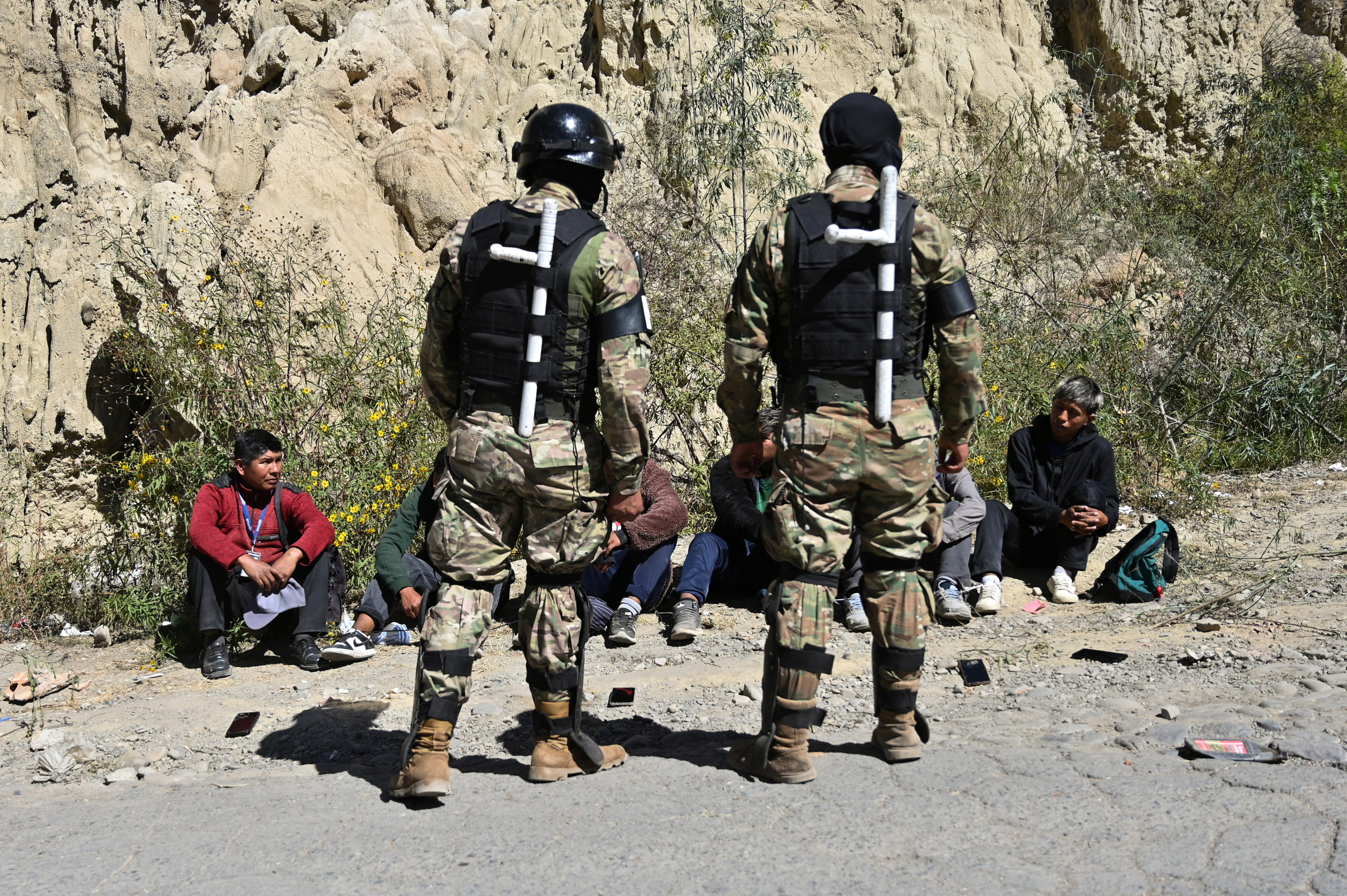 Men detained by police sit on the ground during protests against President Rodrigo Paz's government amid an ongoing economic and fuel crisis, in Lipari, Bolivia, May 16, 2026. REUTERS/Claudia Morales