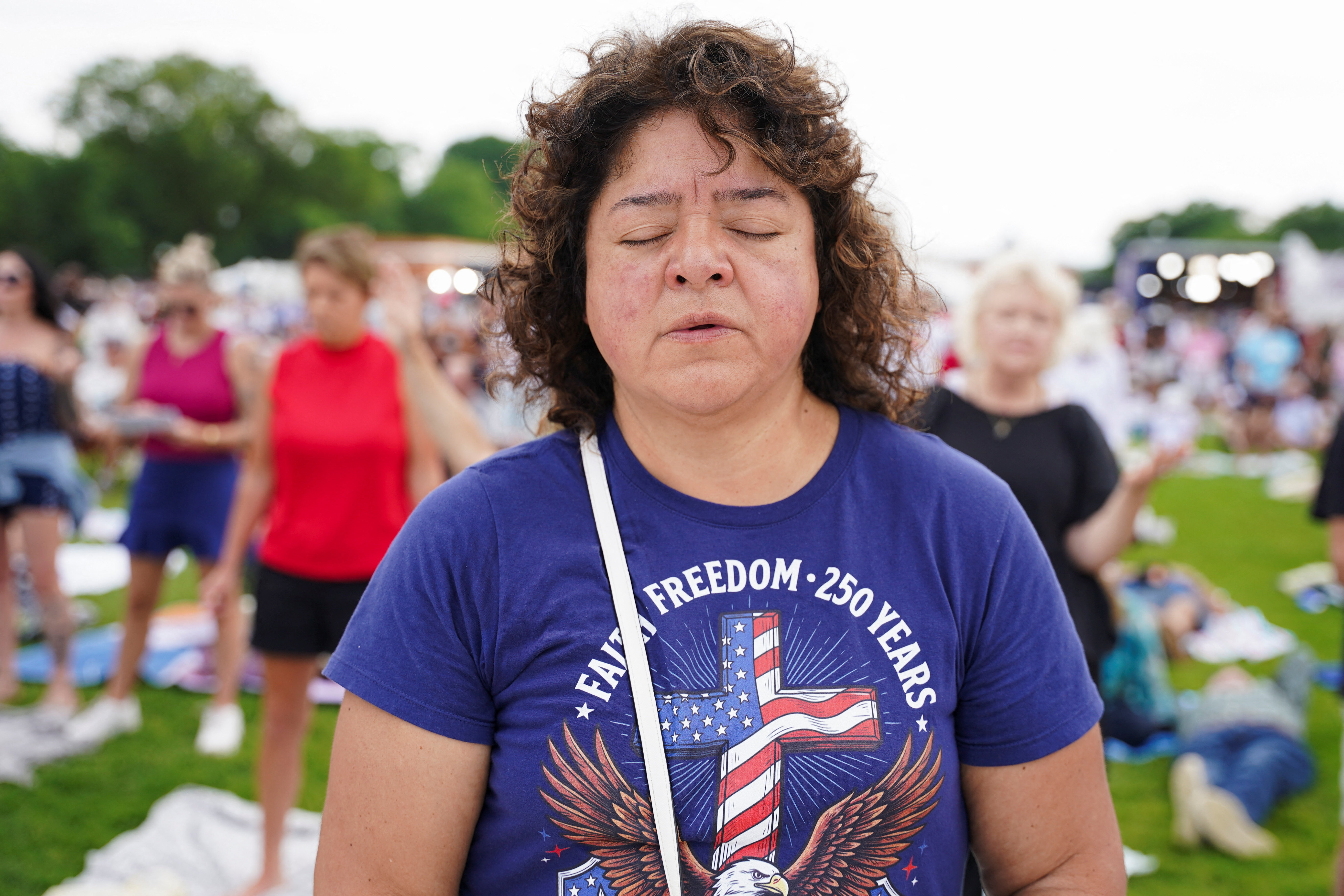 A woman participates in a worship service on the day of Rededicate 250: A National Jubilee of Prayer, Praise & Thanksgiving at the National Mall in Washington, D.C., U.S., May 17, 2026. REUTERS/Seth Herald
