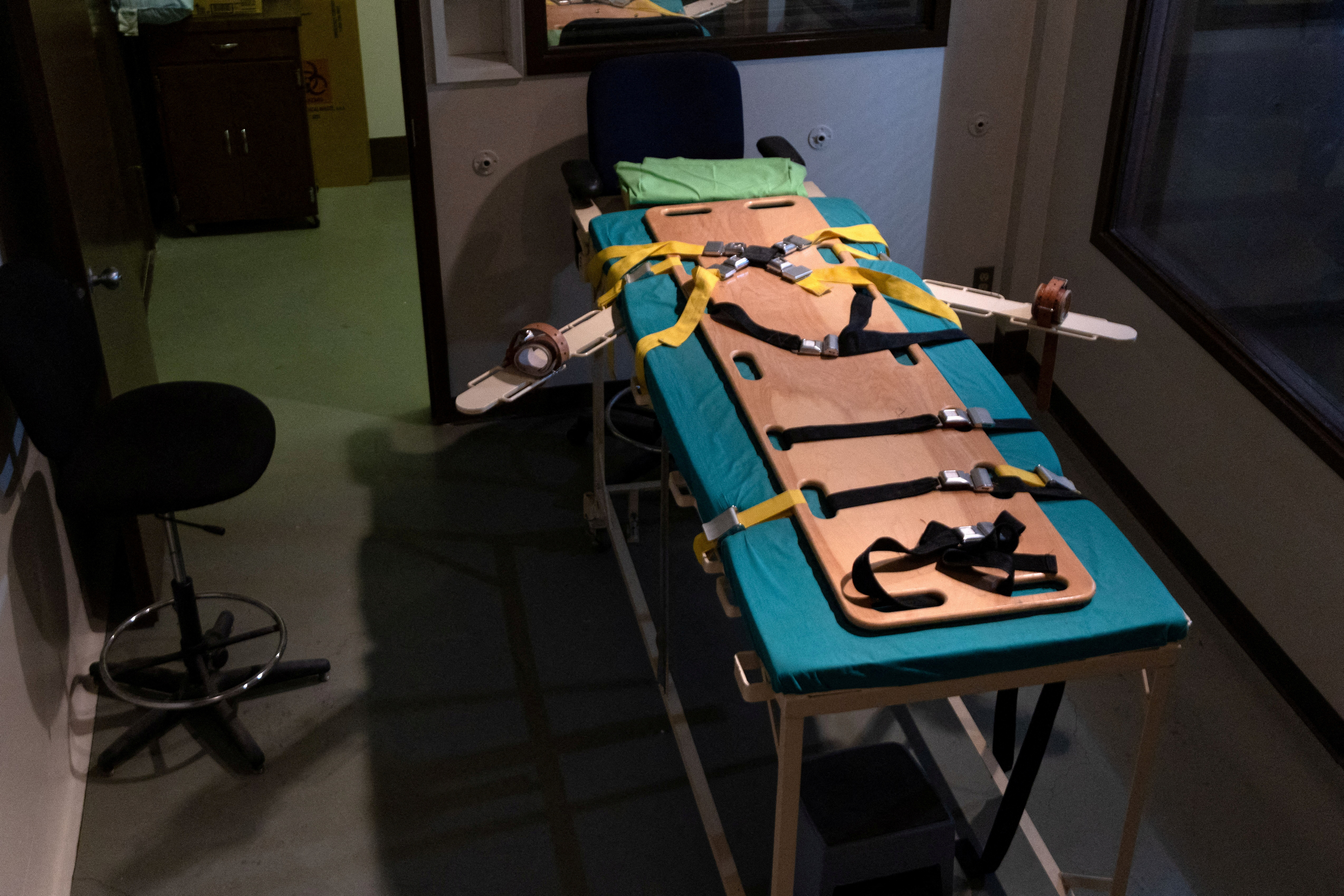 A gurney with straps in a lethal injection chamber