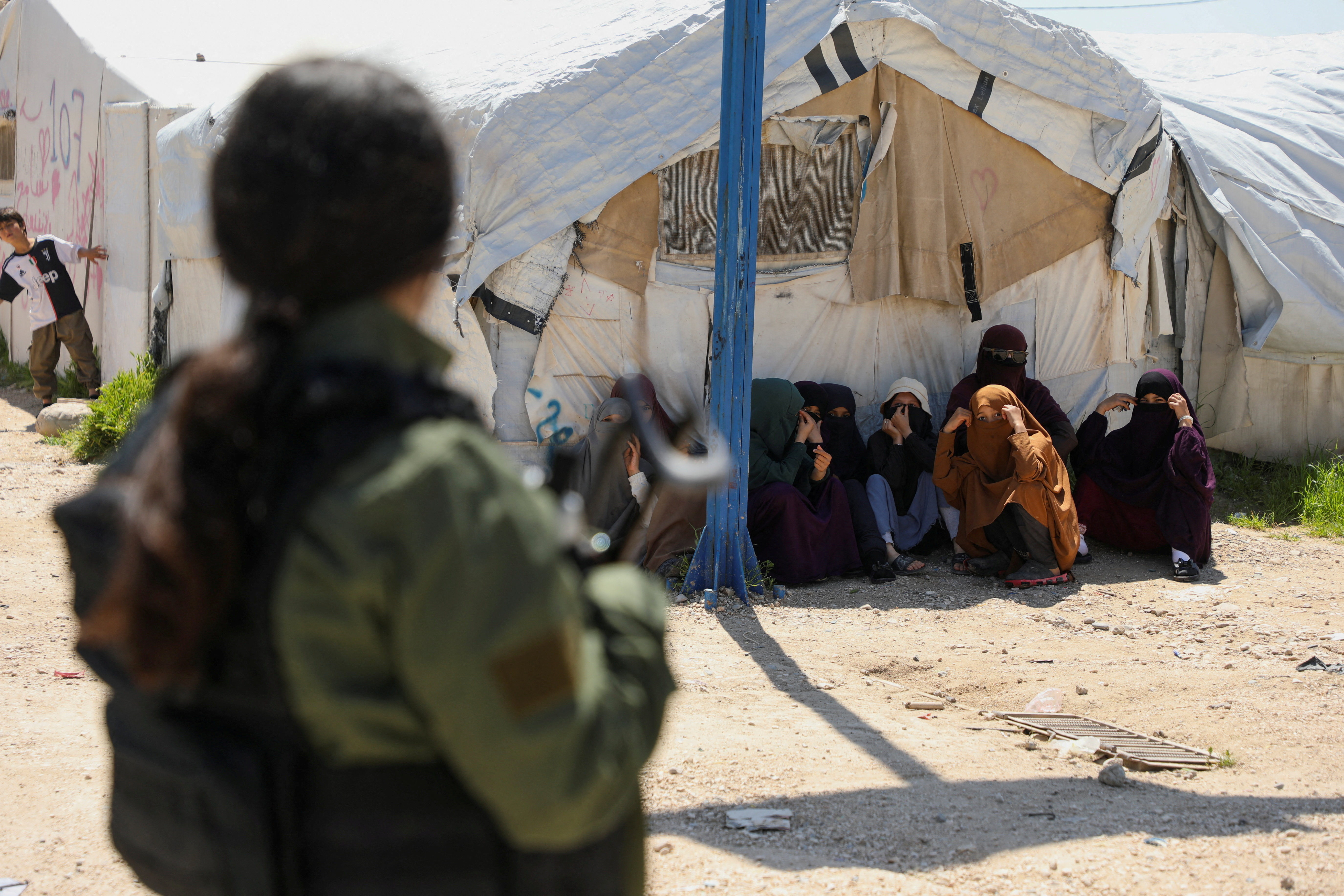 Members of Australian families believed to be linked to the Islamic State militants wait to leave Roj camp near Derik, Syria