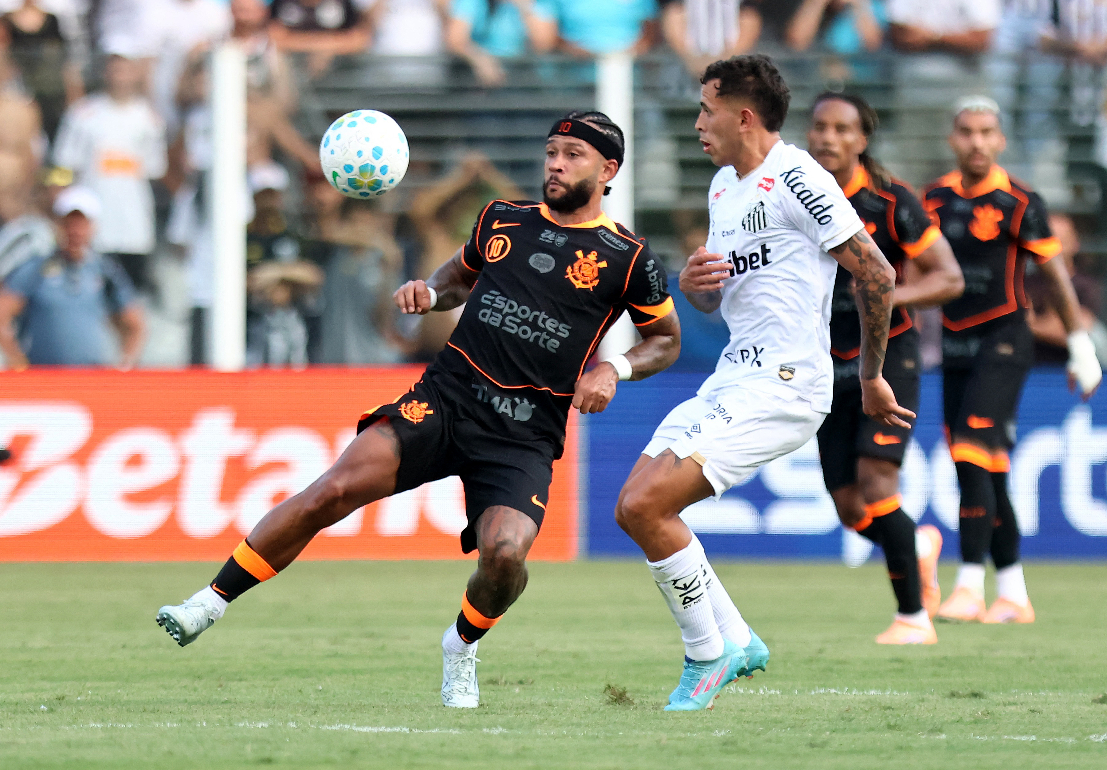 Soccer Football - Brasileiro Championship - Santos v Corinthians - Estadio Urbano Caldeira, Santos, Brazil - March 15, 2026 Corinthians' Memphis Depay in action with Santos' Christian Oliva REUTERS/Thiago Bernardes