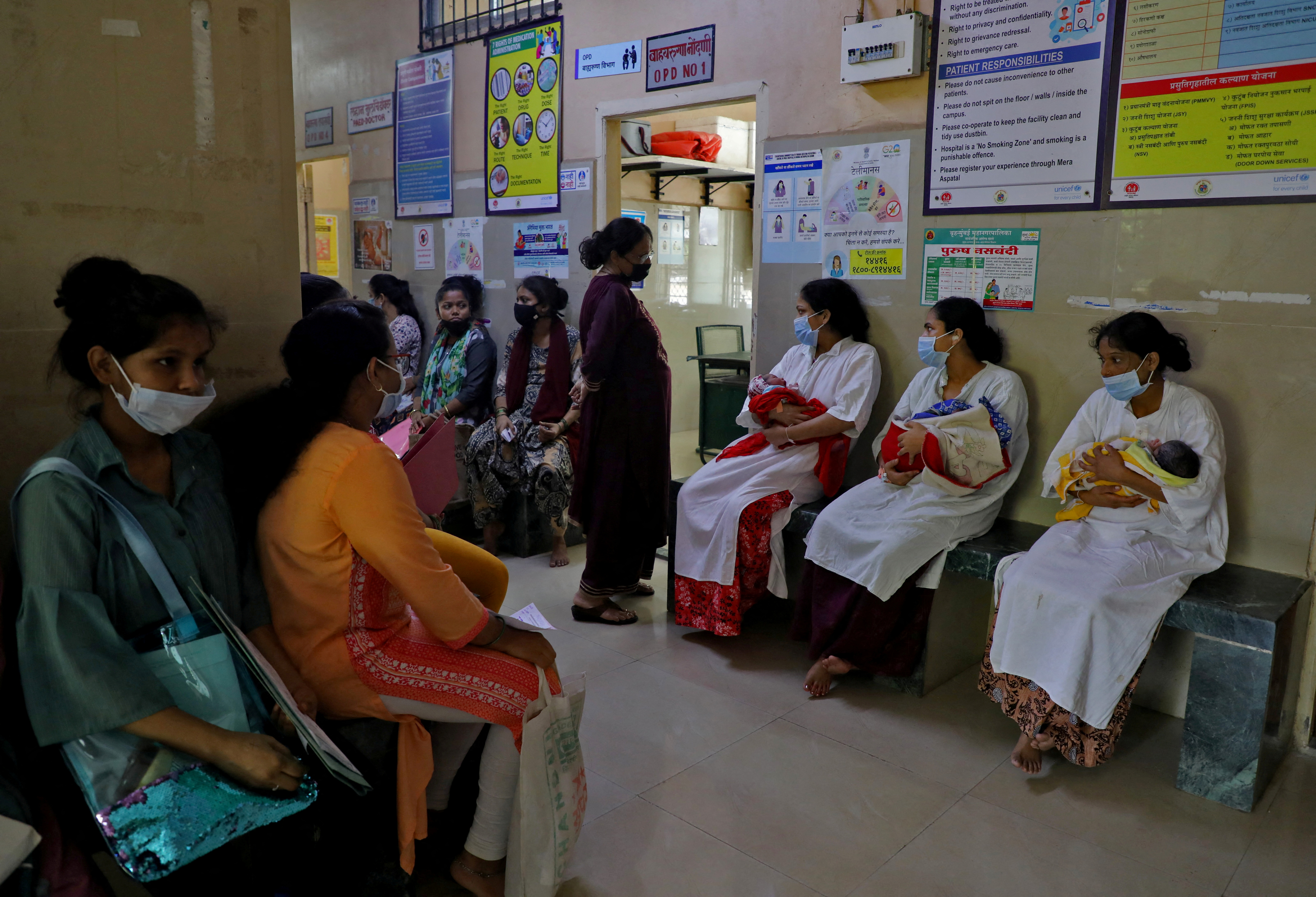 Mothers with their newborns wait their turn for an antenatal examination outside a doctor’s room at a maternity hospital in Mumbai, India