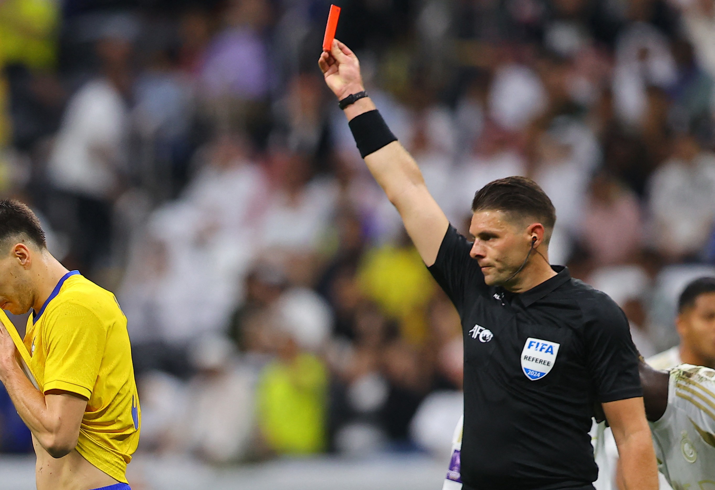 Al Gharafa's Seydou Sano is shown a red card by referee Shaun Evans.