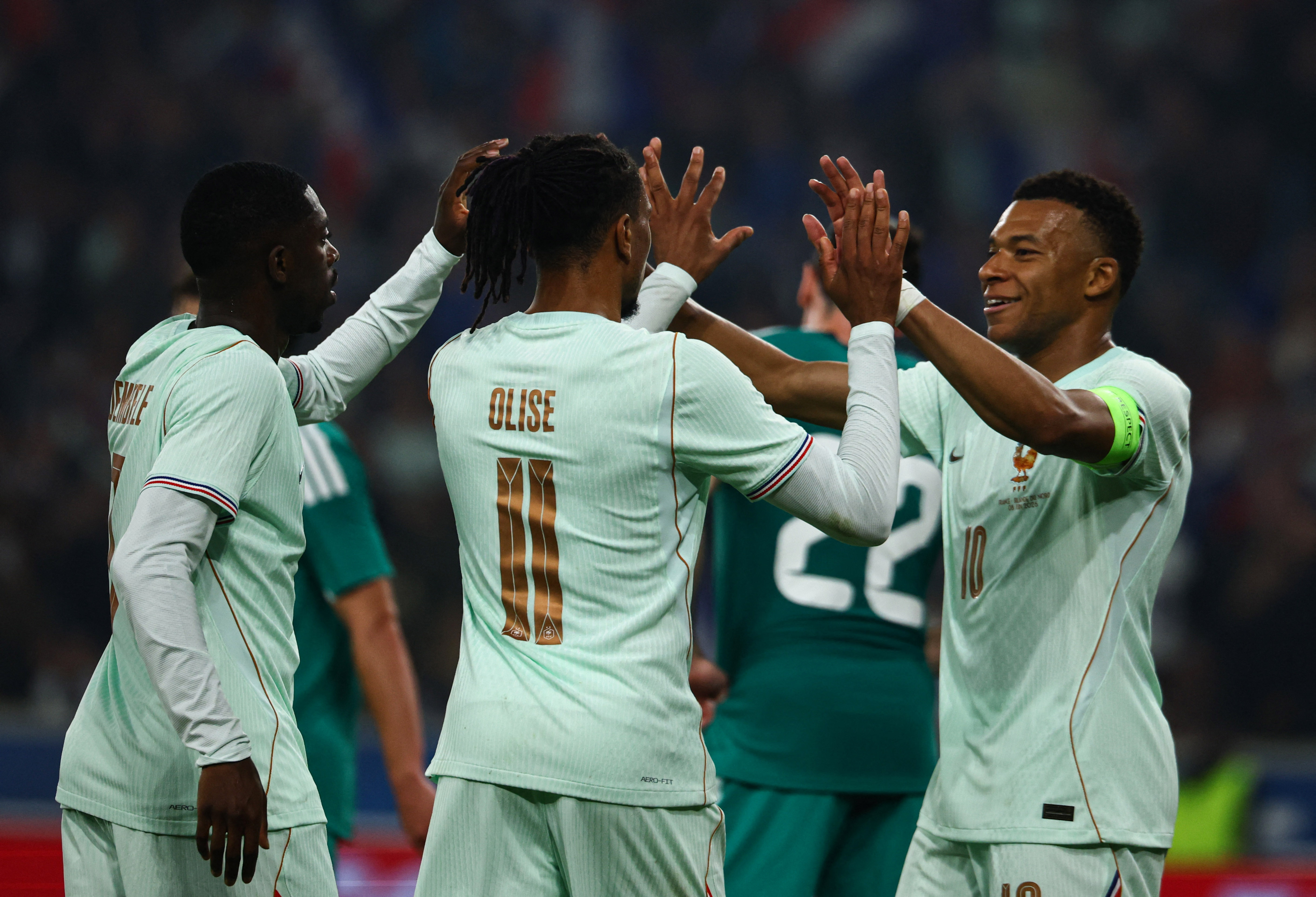 Michael Olise celebrates scoring their first goal against Northern Ireland with Ousmane Dembele and Kylian Mbappe