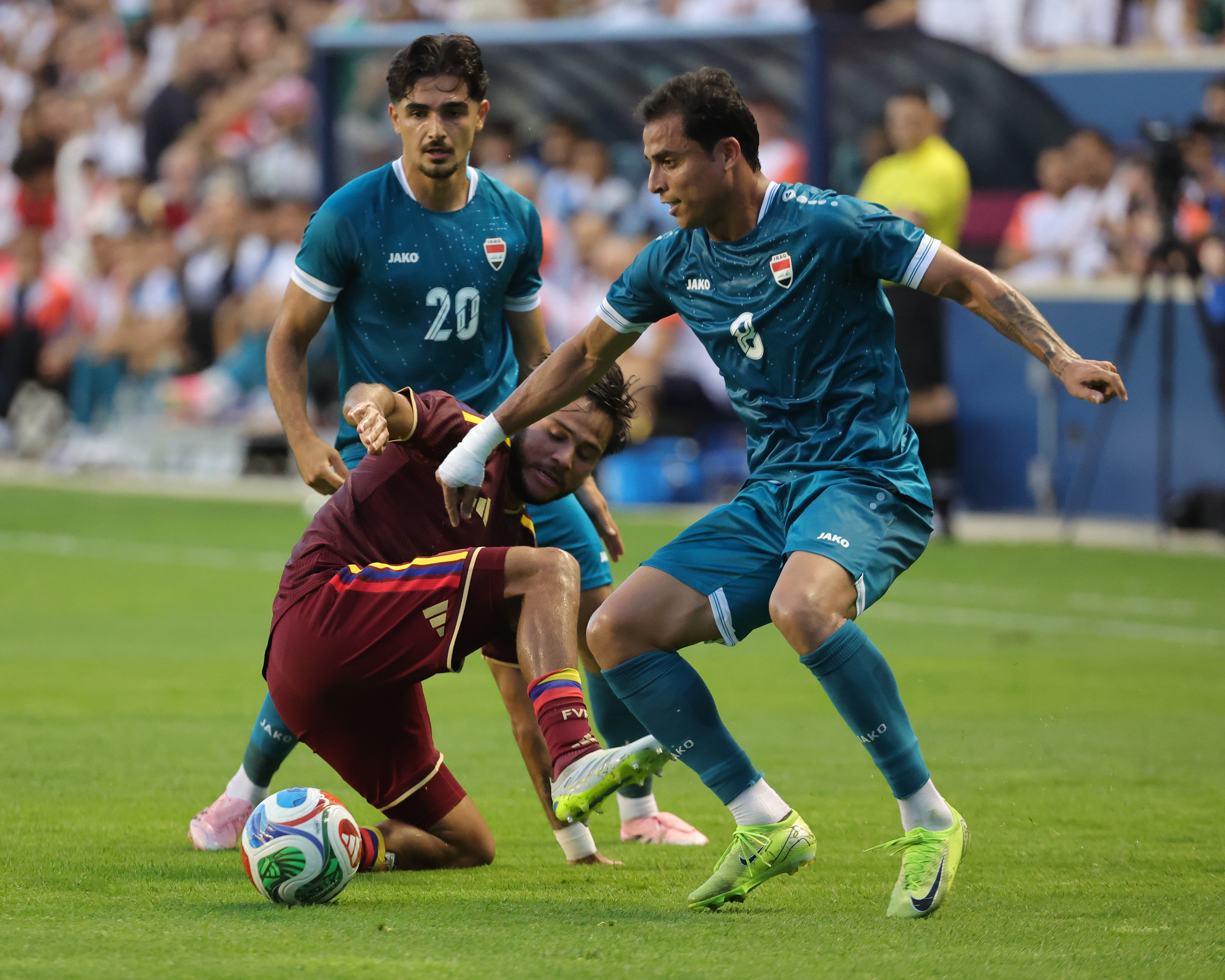 Iraq and Venezuela players tussle for the ball