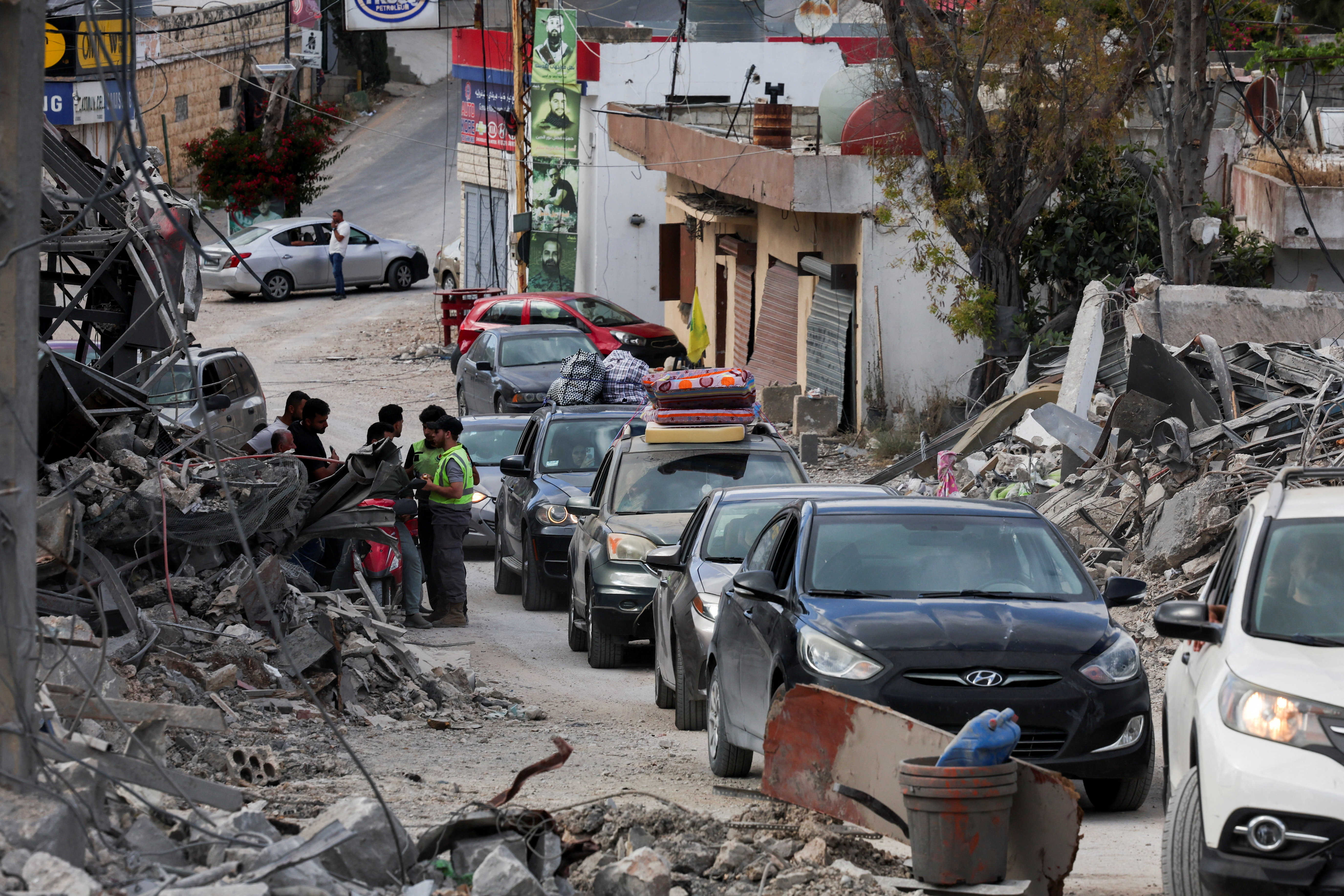 Displaced people transport their belongings in cars.