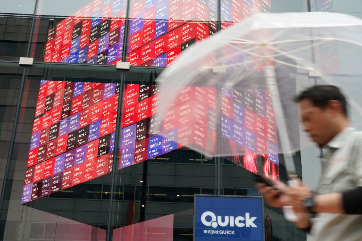 A man walks next to an electronic quotation board displaying the Nikkei 225 stock prices on the Tokyo Stock Exchange in Tokyo, Japan, on June 18, 2026