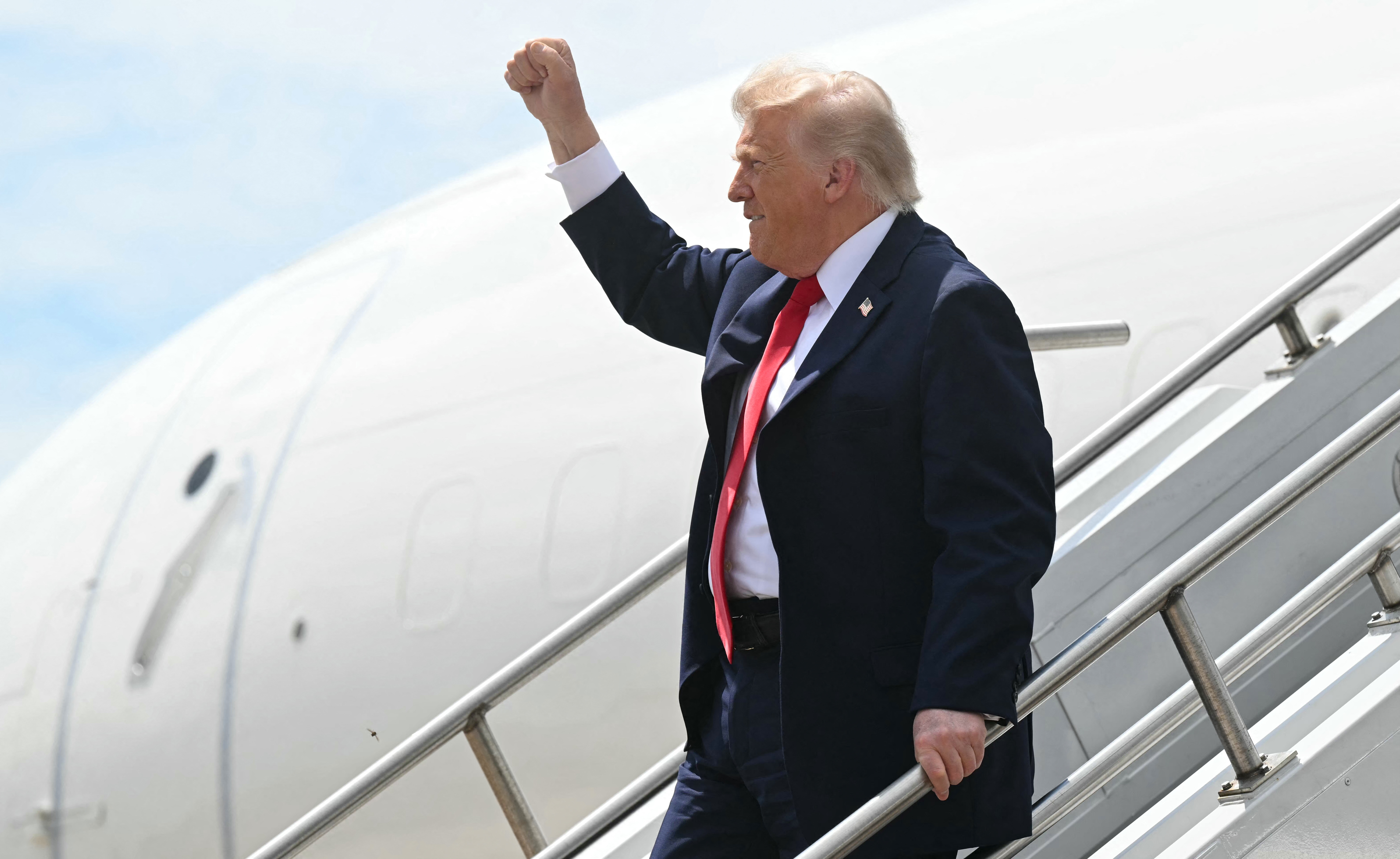 US President Donald Trump raises his fist as he disembarks from Air Force One at Chippewa Valley Regional Airport in Eau Claire, Wisconsin, on June 5, 2026.
