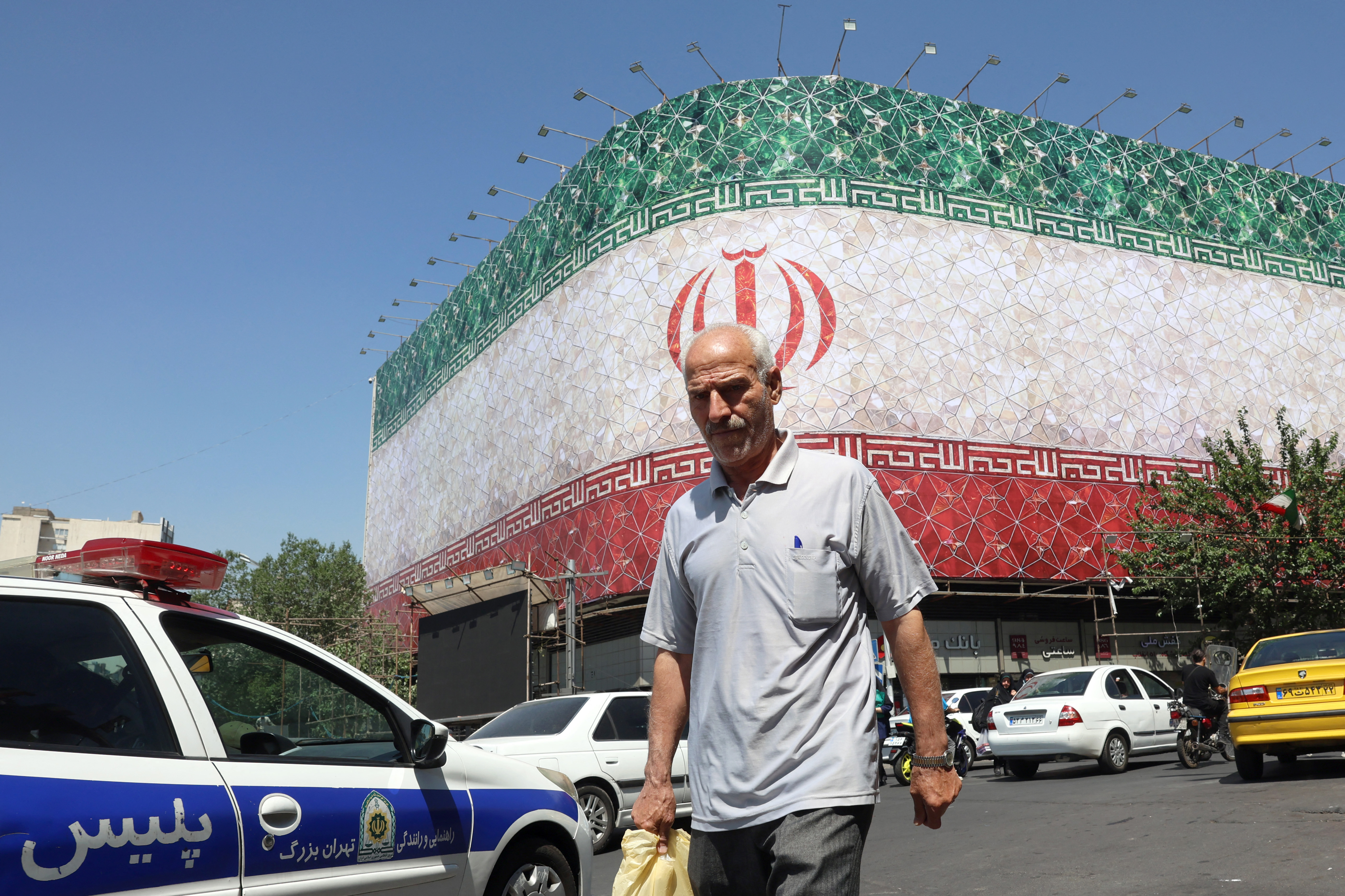 The Iranian national flag is displayed on a building.