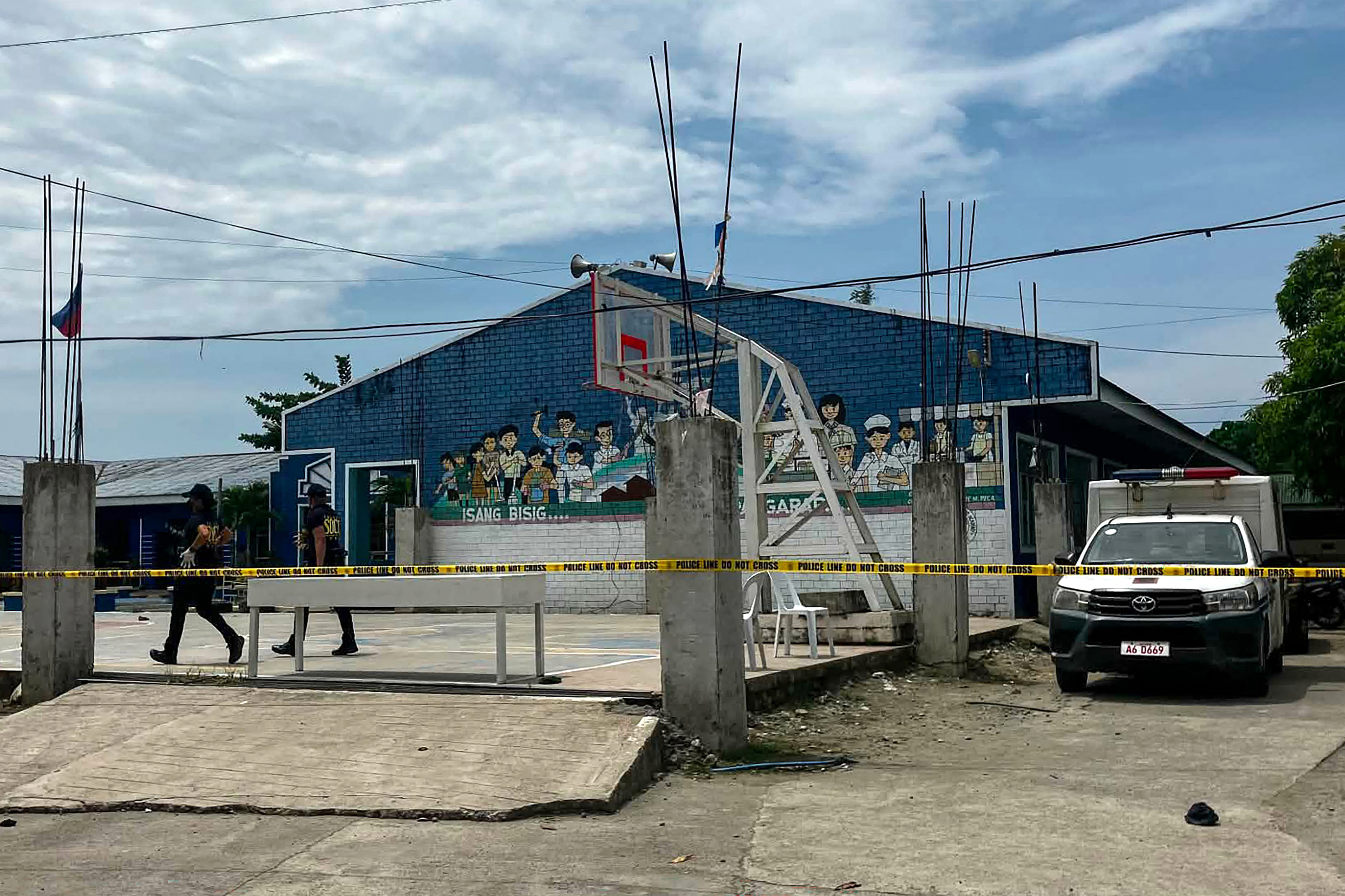 Police investigators walk in front of the school entrance after a shooting incident at a high school compound in Tacloban City, Leyte province on June 22, 2026.