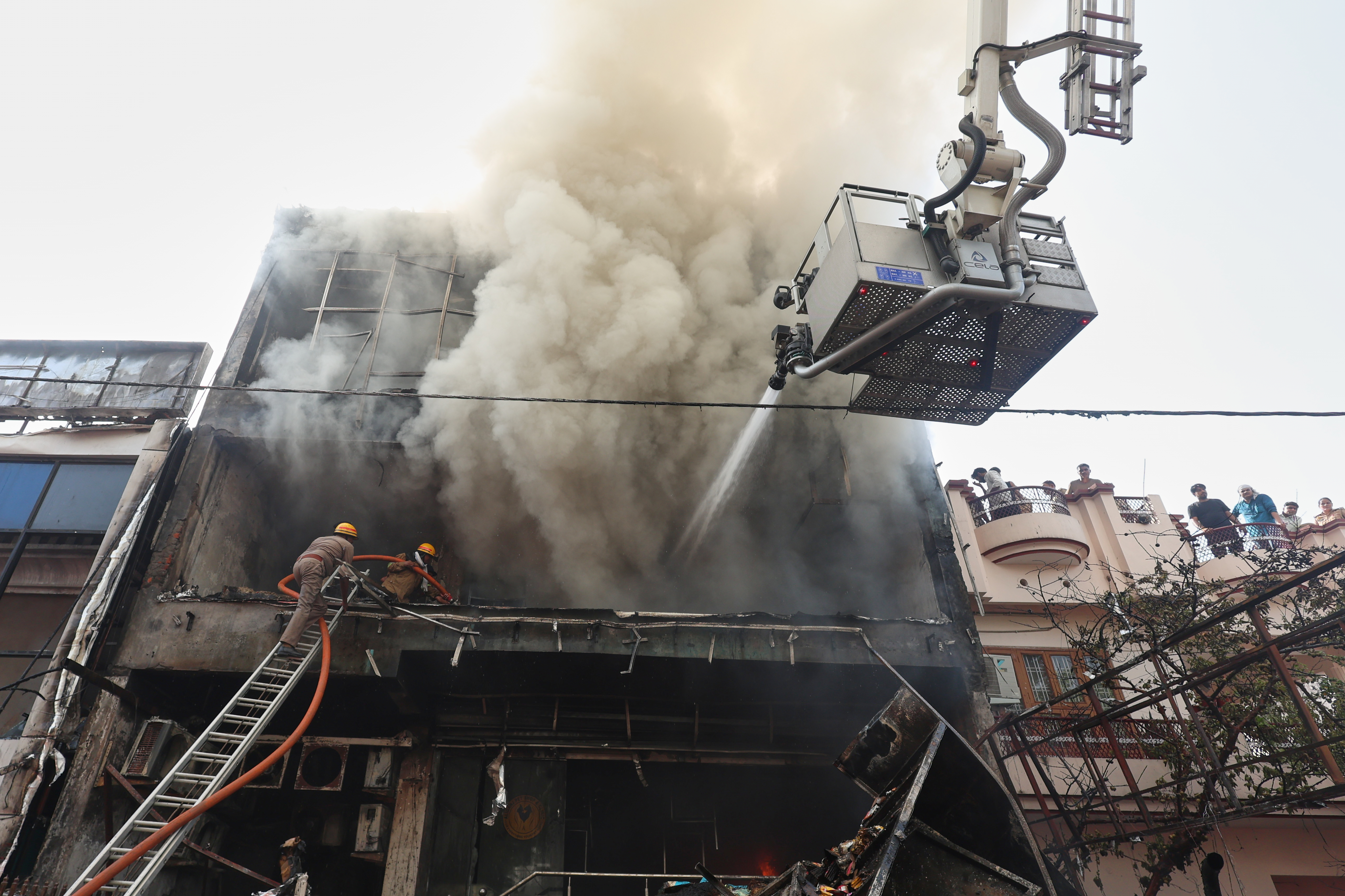 Firefighters work to put out a fire in a commercial building in Lucknow, India, Monday, June 22, 2026. (AP Photo/Sumit Kumar)