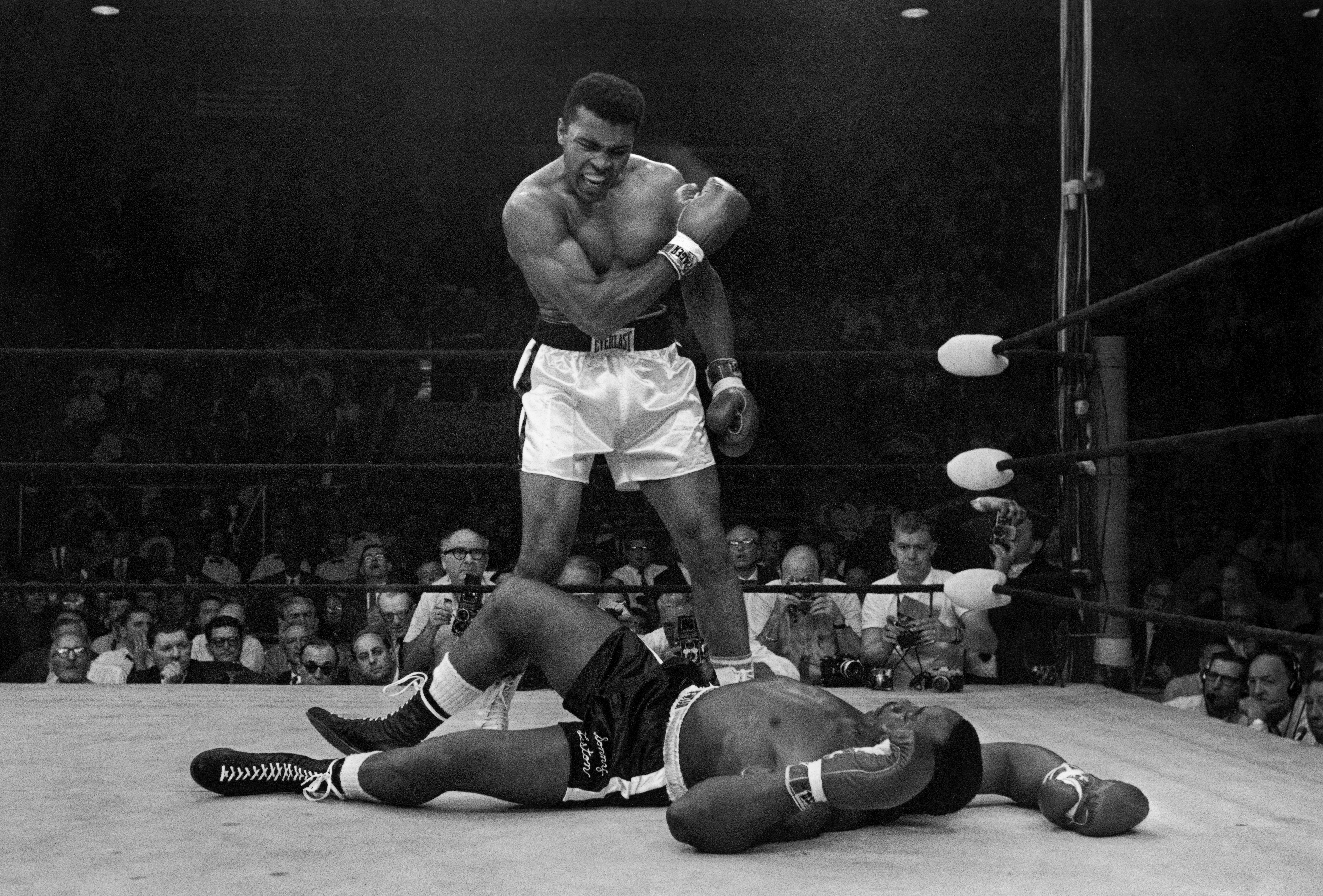 Heavyweight champion Muhammad Ali stands over fallen challenger Sonny Liston, shouting and gesturing shortly after dropping Liston with a short hard right to the jaw on May 25, 1965, in Lewiston, Maine. (AP Photo/John Rooney, file)