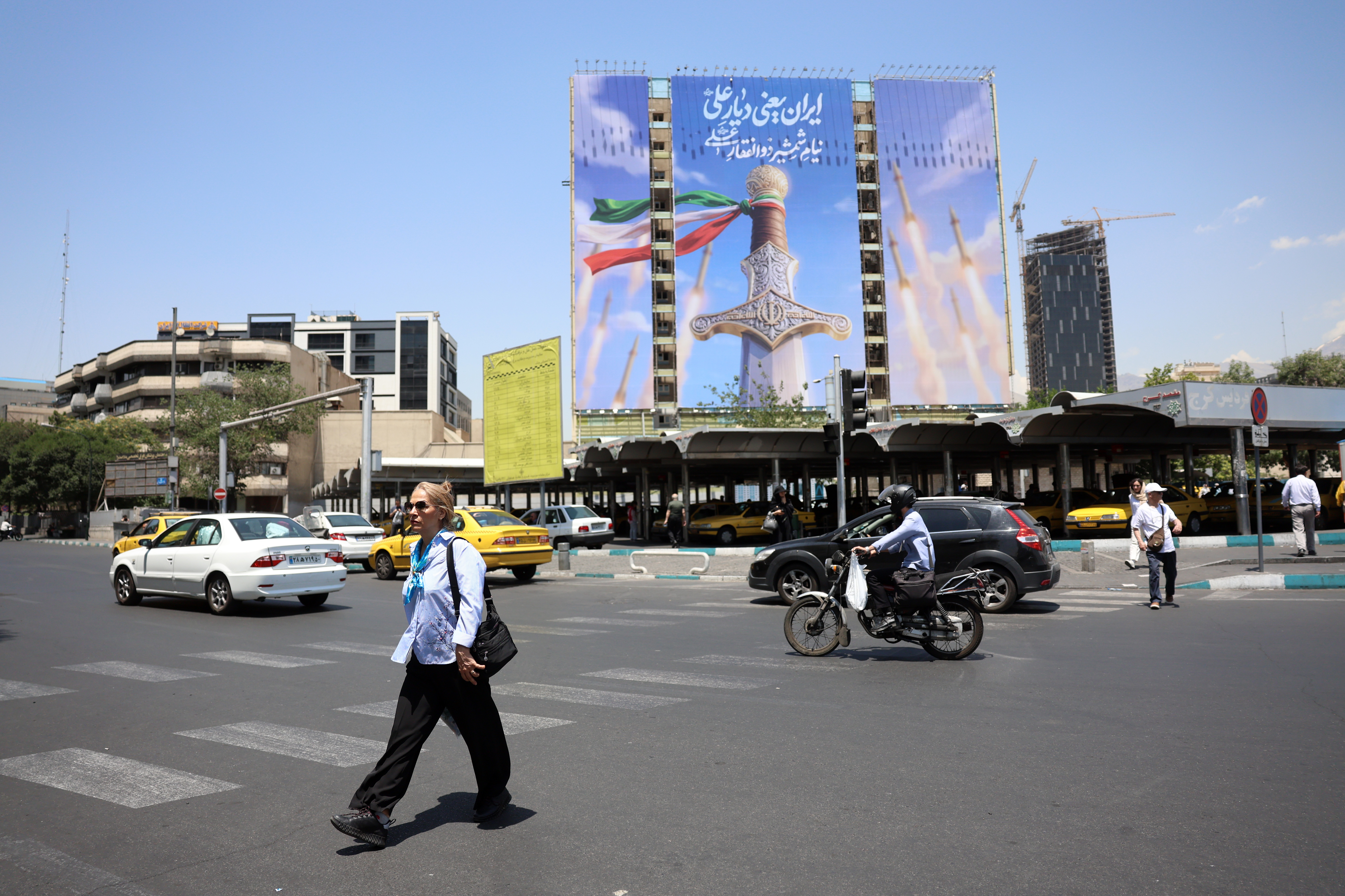epa13029911 Iranians walk past a large-scale political billboard featuring Iranian missiles and a sword at Vanak square in Tehran, Iran, 11 June 2026. A ceasefire framework established between Washington and Tehran in April faces increasing strain following a series of US airstrikes across Iran and subsequent retaliatory missile barrages by the Islamic Revolutionary Guard Corps (IRGC) targeting US regional bases. EPA/ABEDIN TAHERKENAREH RESTRICTIONS: NO Access Israel Media/Persian Language TV Stations Outside Iran/Strictly No Access BBC Persian/VOA Persian/Manoto TV/Iran International TV. (As mandated by Iran's Directorate General for Foreign Media) --