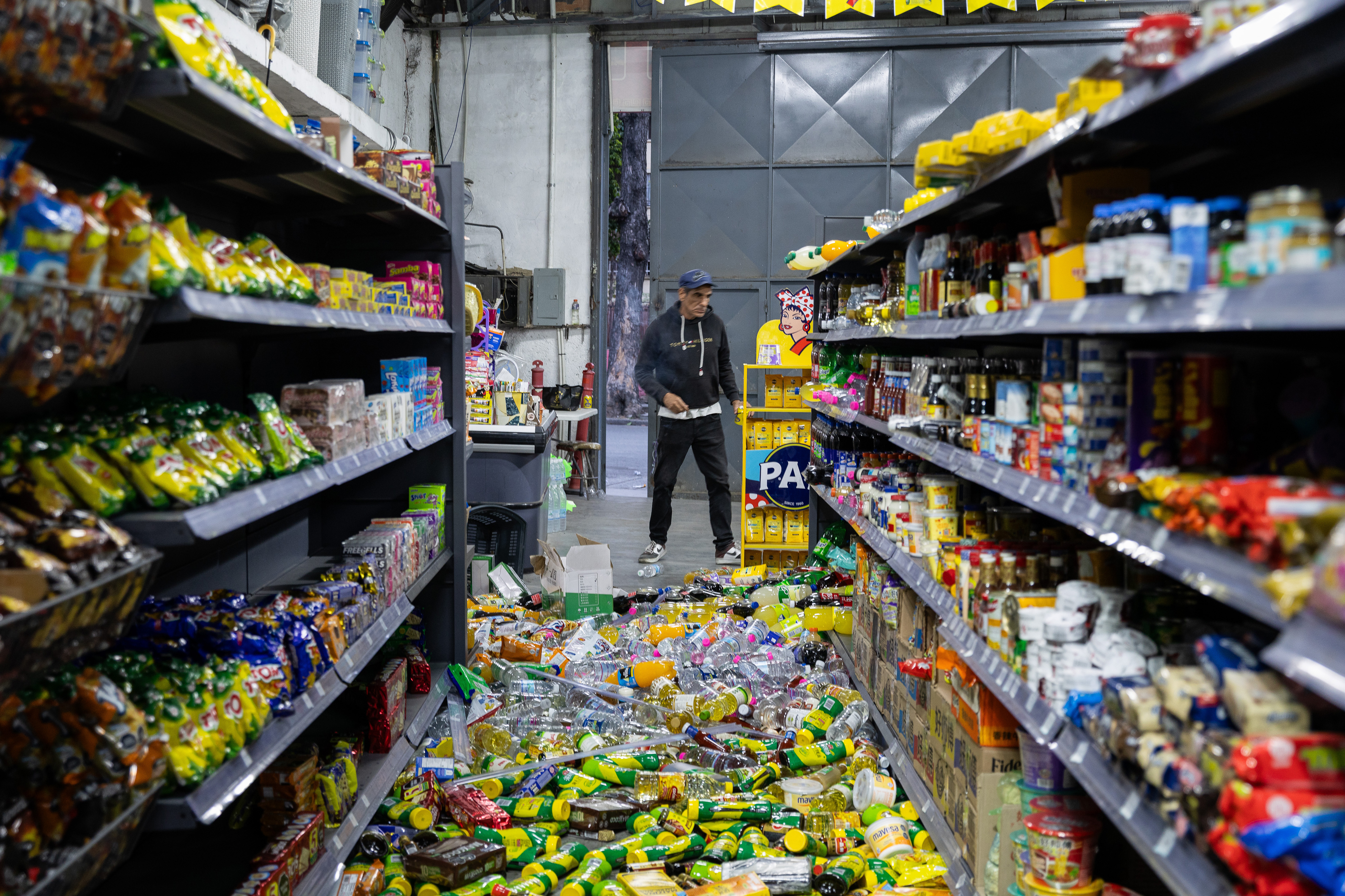 epa13062570 A person looks at spilled groceries at a warehouse in Caracas, Venezuela, 24 June 2026. Two powerful earthquakes struck Venezuela, including a magnitude 7.5 earthquake, causing buildings to collapse as authorities assessed damage and possible casualties, according to the US Geological Survey (USGS) and local officials. EPA/RAYNER PENA