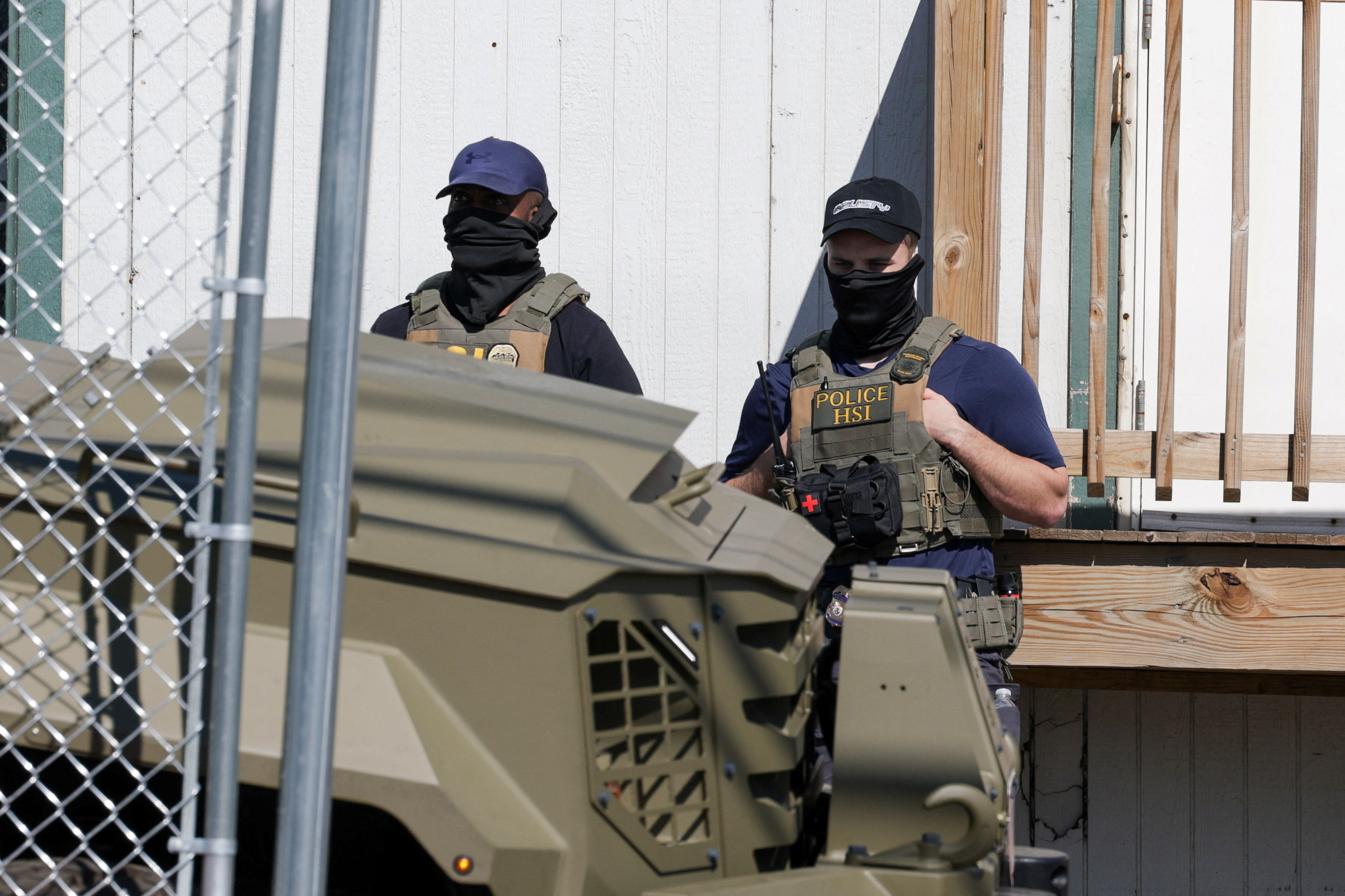 US Immigration and Customs Enforcement (ICE) agents stand guard.