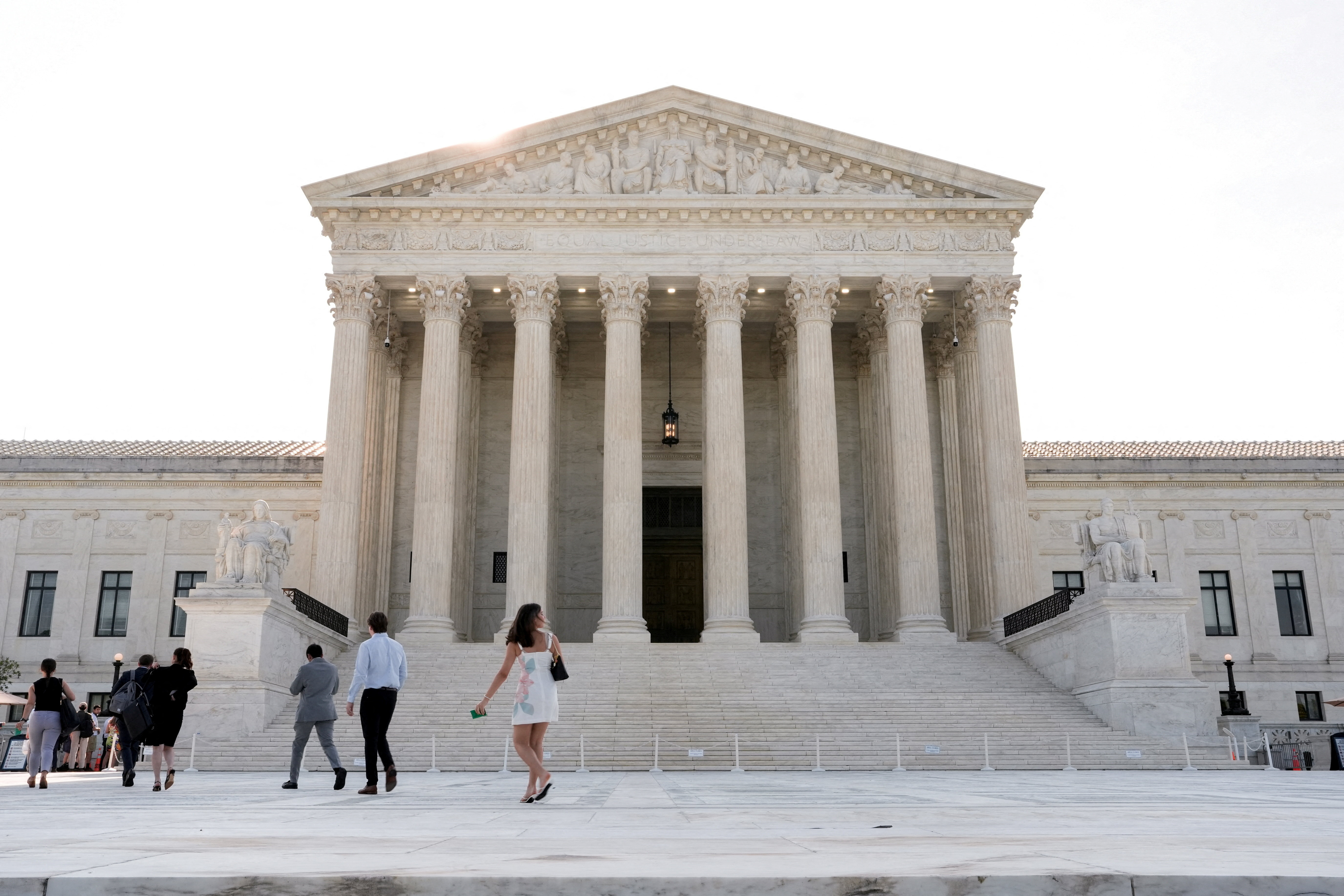 People walk in front of the Supreme Court building, as the court is set to issue the final rulings of its nine-month term, in Washington, D.C., U.S., June 30, 2026. REUTERS/Cheney Orr