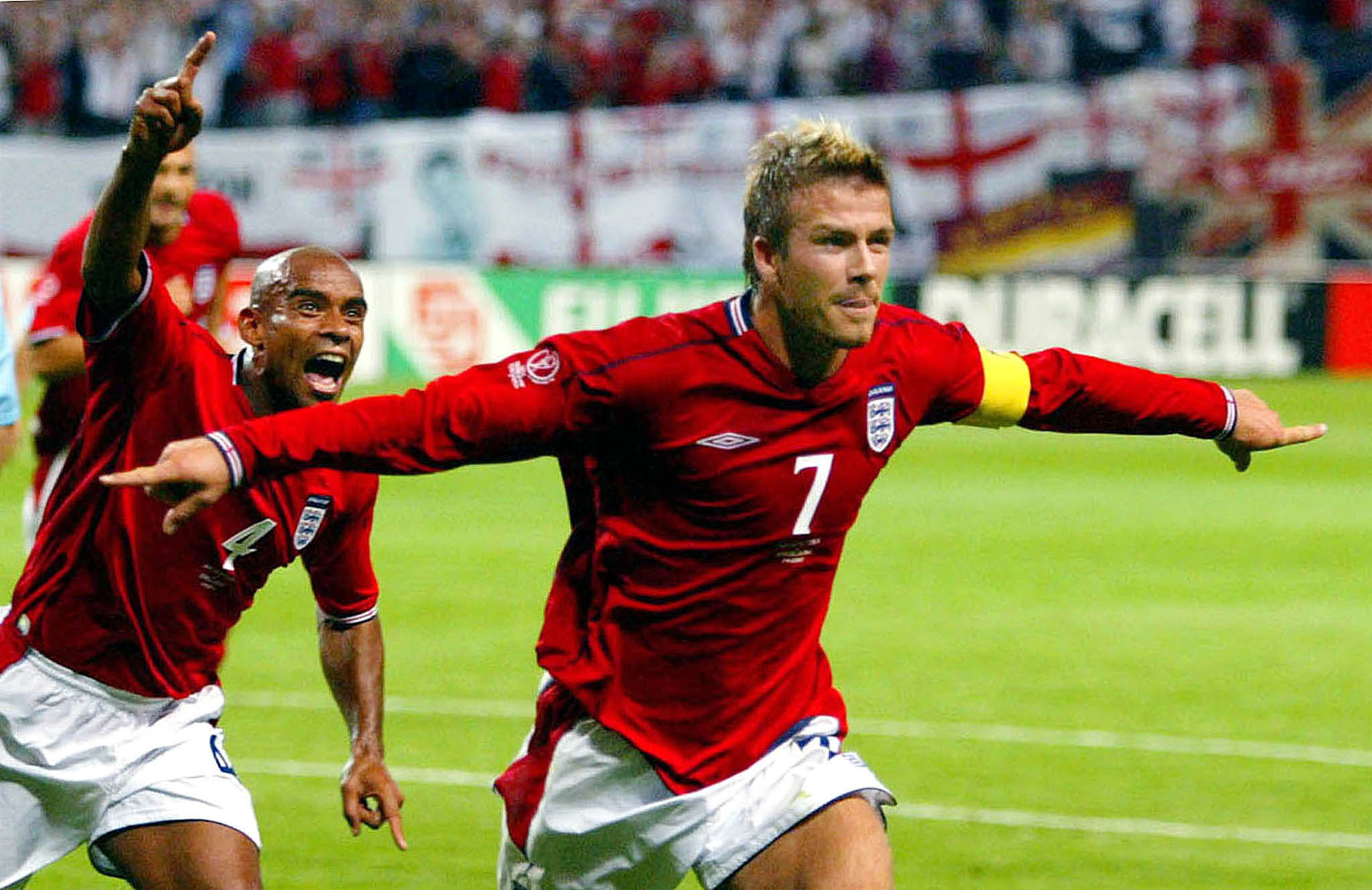 England captain David Beckham (R) runs in celebration with team mate Trevor Sinclair after scoring from the penalty spot against [Argentina] during their group F World Cup Finals match at the Sapporo Dome stadium June 7, 2002. [England were awarded a penalty after striker Michael Owen was tripped inside the penalty area.]