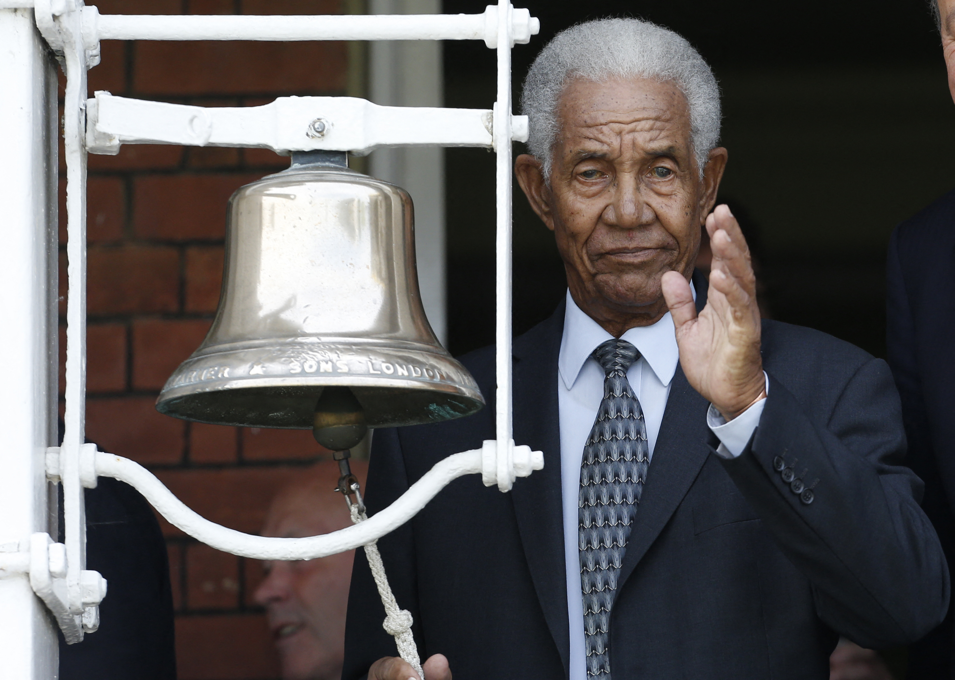 (FILES) West Indian cricket legend Sir Garfield Sobers waves as he rings the five minute bell before the start of the second session in memory of Muhammad Ali on the second day of the third Test cricket match between England and Sri Lanka at Lord's cricket ground in London on June 10, 2016. Gary Sobers, arguably the greatest ever cricketer, has died aged 89 West Indies Cricket announced on July 17, 2026. (Photo by IAN KINGTON / AFP) / RESTRICTED TO EDITORIAL USE. NO ASSOCIATION WITH DIRECT COMPETITOR OF SPONSOR, PARTNER, OR SUPPLIER OF THE ECB