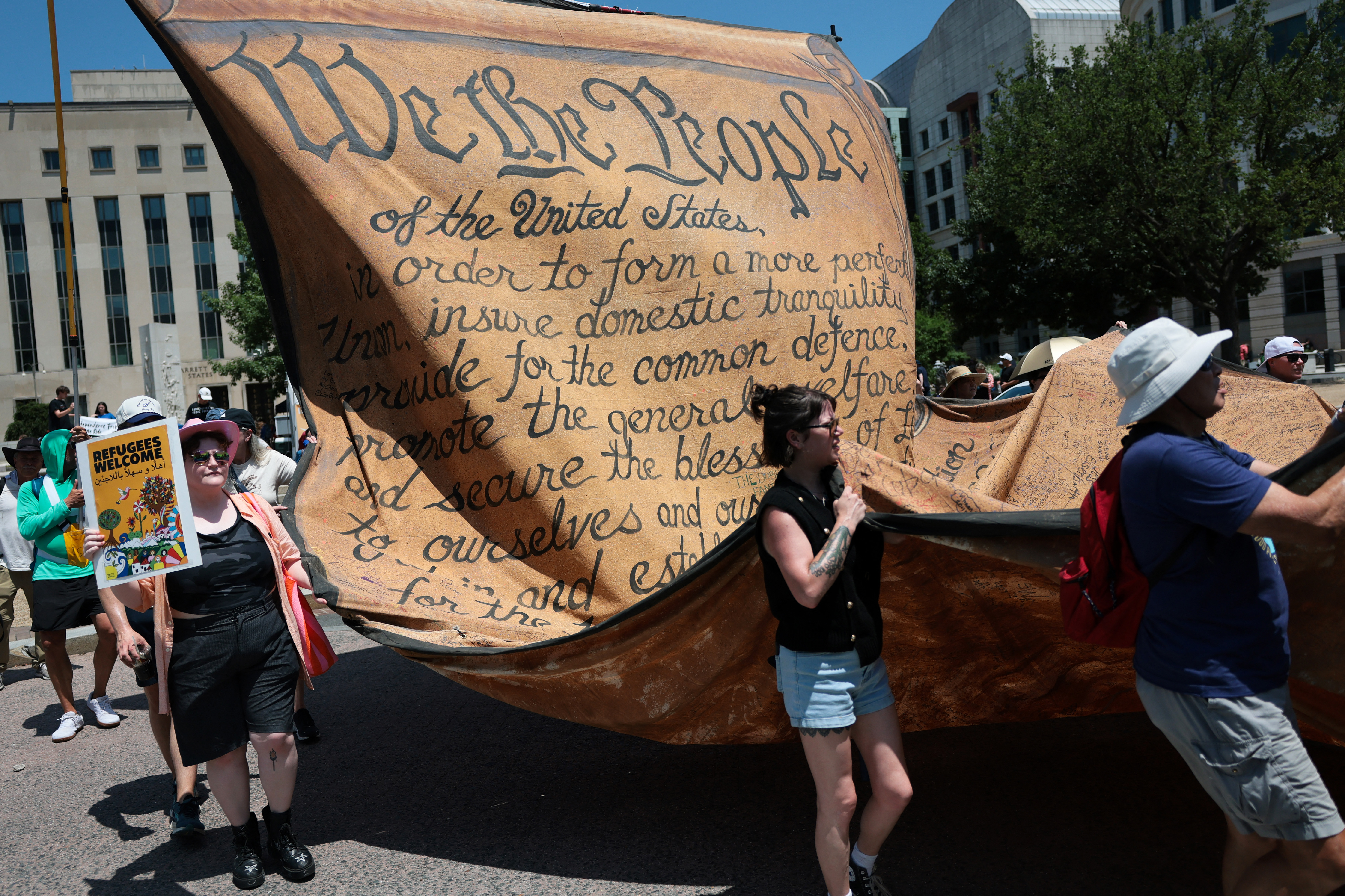 WASHINGTON, DC - JULY 04: Protesters carry a reproduction of the Declaration of Independence as they participate in a "We The People 250" march during Fourth of July celebrations on July 04, 2026 in Washington, DC. Numerous events, activities, and fireworks are planned in celebration of America's 250th Anniversary amidst an extreme heat wave bringing dangerous triple digit temperatures to much of the eastern United States. Joe Raedle/Getty Images/AFP (Photo by JOE RAEDLE / GETTY IMAGES NORTH AMERICA / Getty Images via AFP)