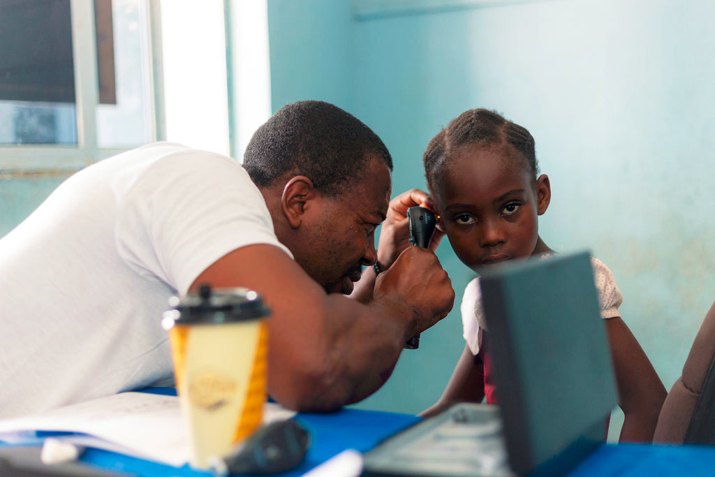 A doctor checks a child’s ear during a medical outreach [Humserve Africa Foundation]