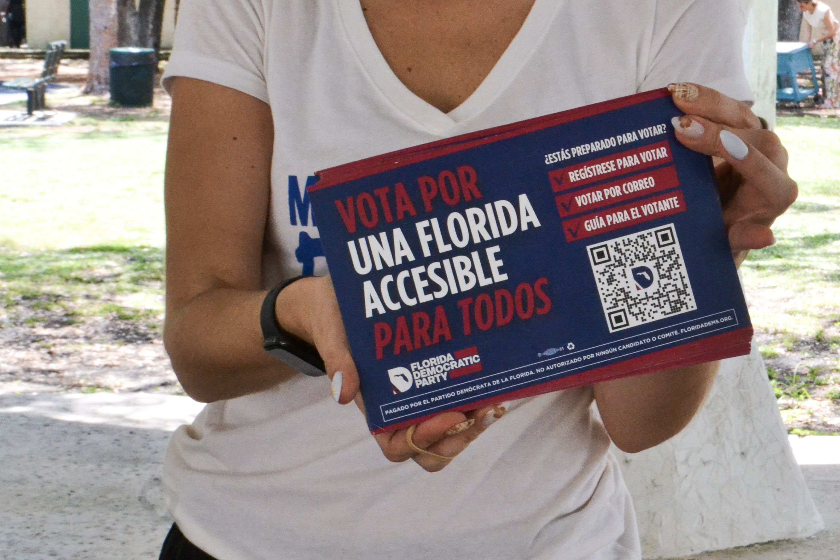 A Democratic campaigner holds up a pamphlet in Spanish, calling on voters to cast their ballot for a