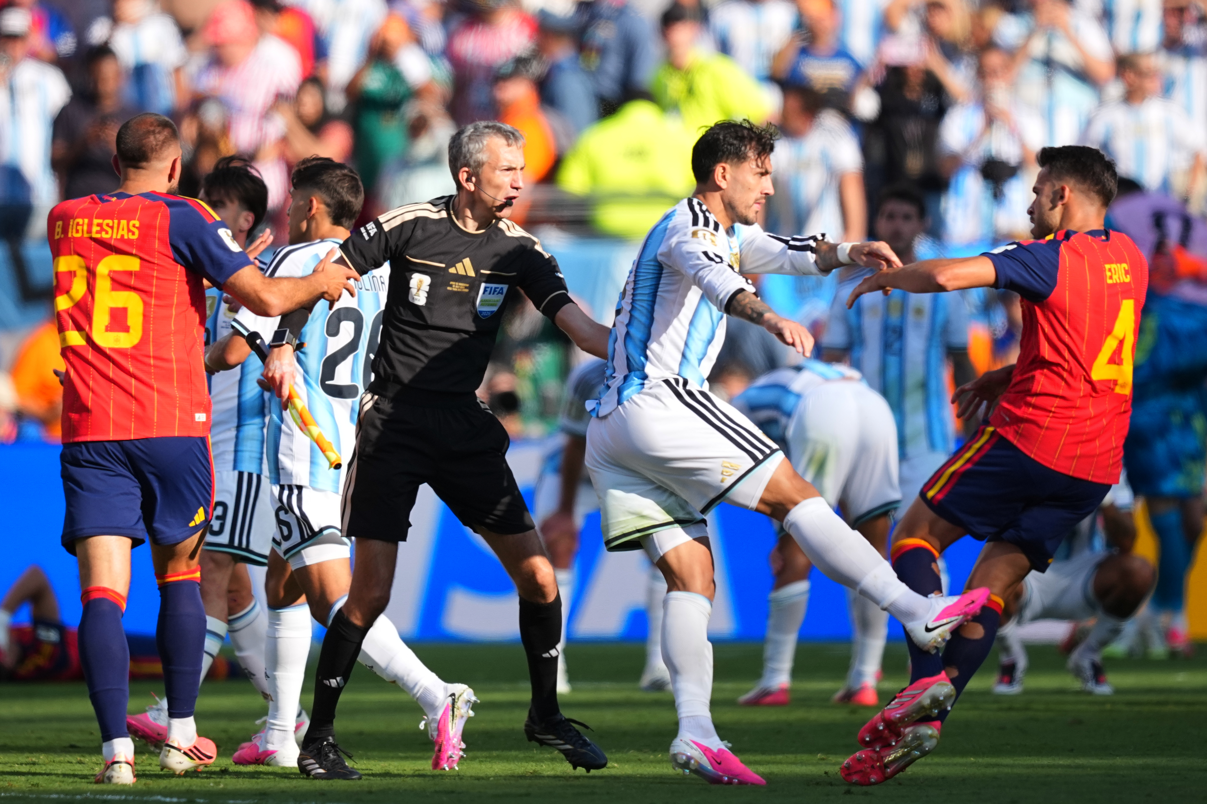 Argentina's Leandro Paredes (5) kicks at Spain's Eric Garcia (4) as assistant referee Tomaz Klancnik, of Slovenia, tries to break up a scuffle after the World Cup final soccer match between Spain and Argentina