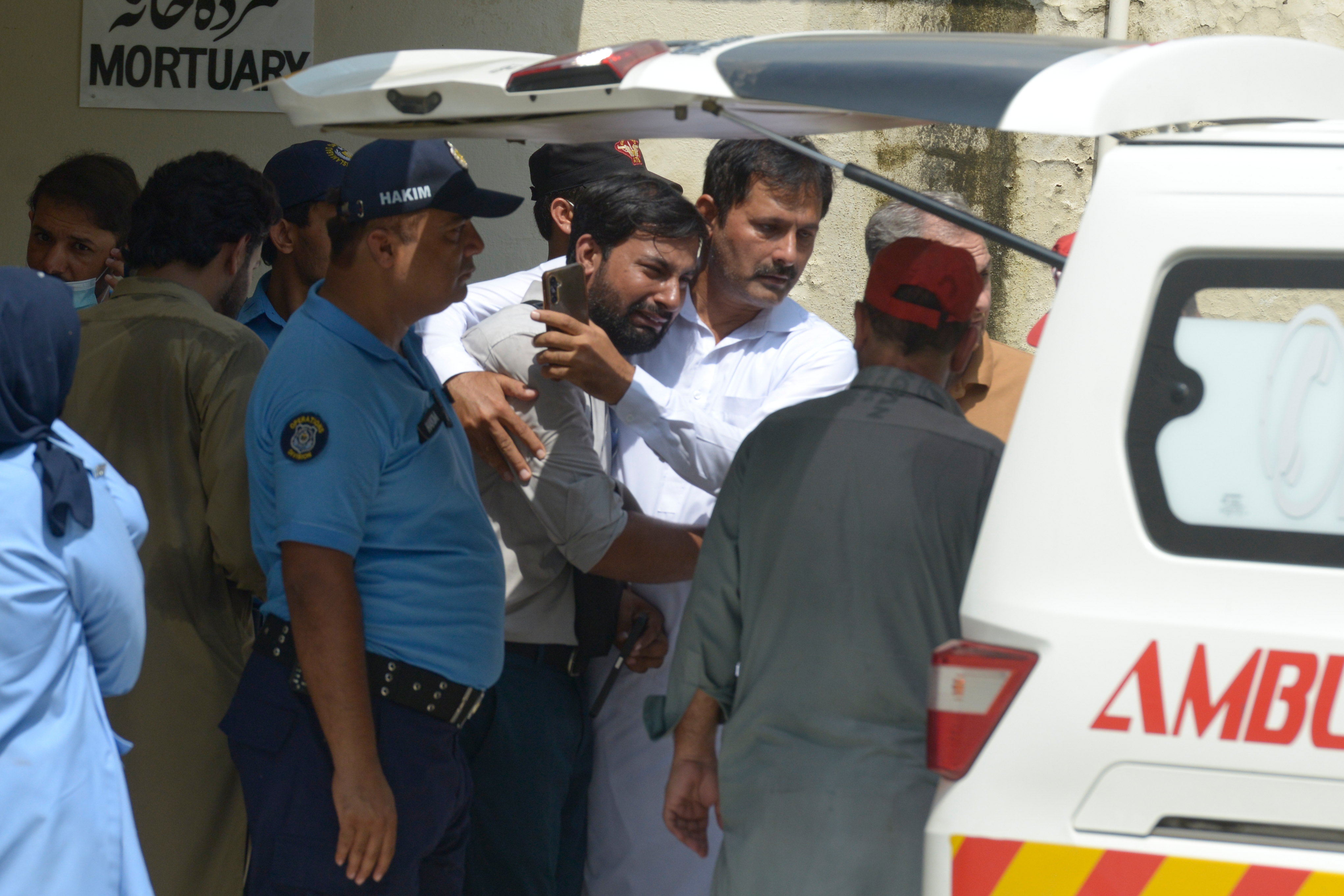 A father, center, of a victim in a fire is comforted as his child's coffin is carried outside a hospital in Islamabad, Pakistan, Wednesday, Aug. 26, 2026. (AP Photo/M.A. Sheik) CORRECTION: Corrects date/day